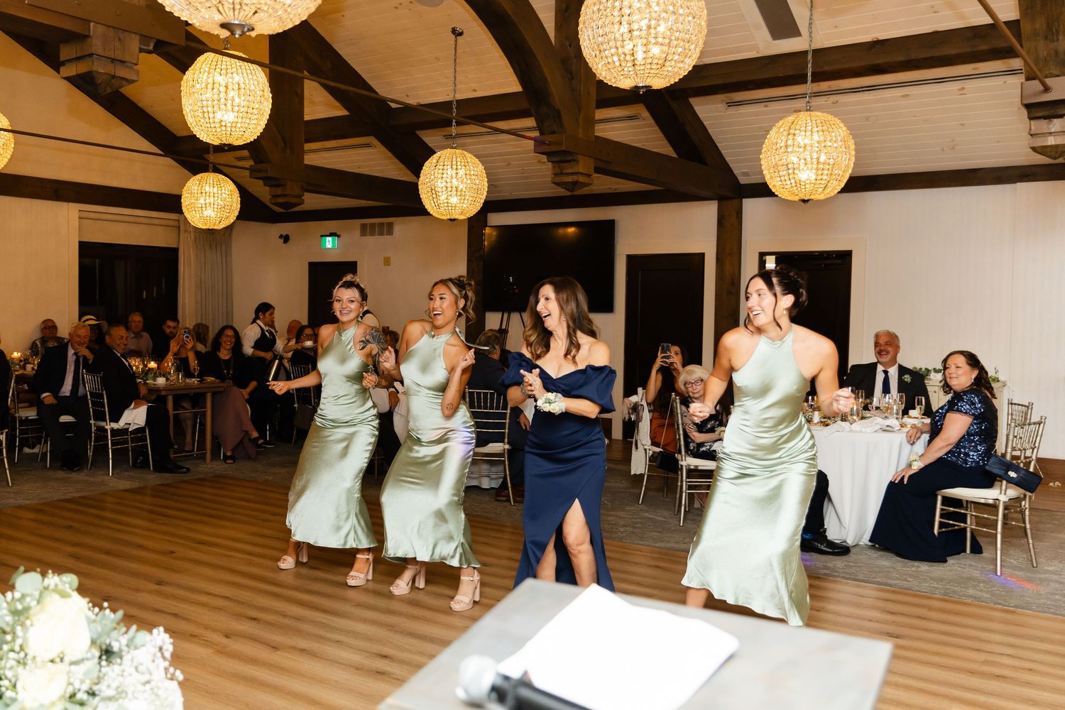 Wedding reception venue decorated with elegant hanging lanterns and exposed wooden beams.