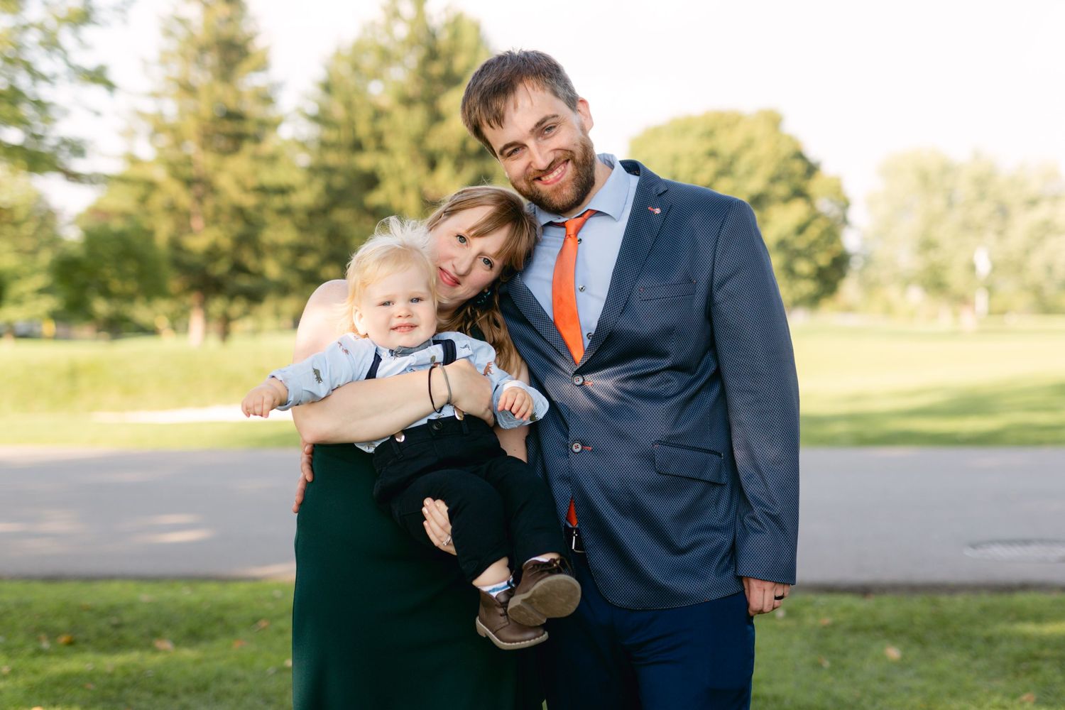 Family portrait outdoors with toddler in casual formal wear.