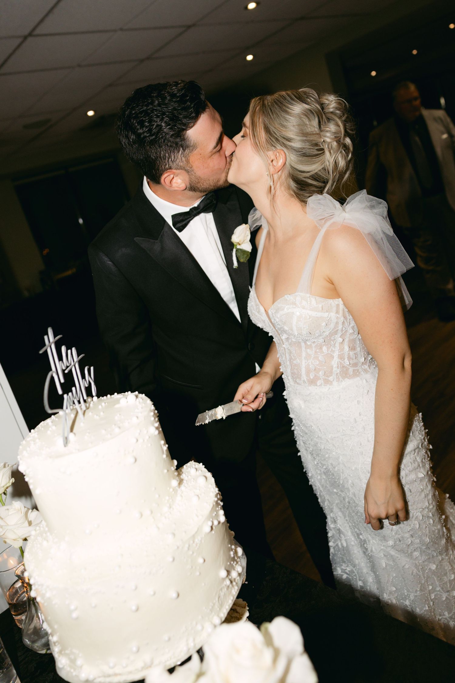 Couple participates in traditional wedding cake feeding moment at reception.