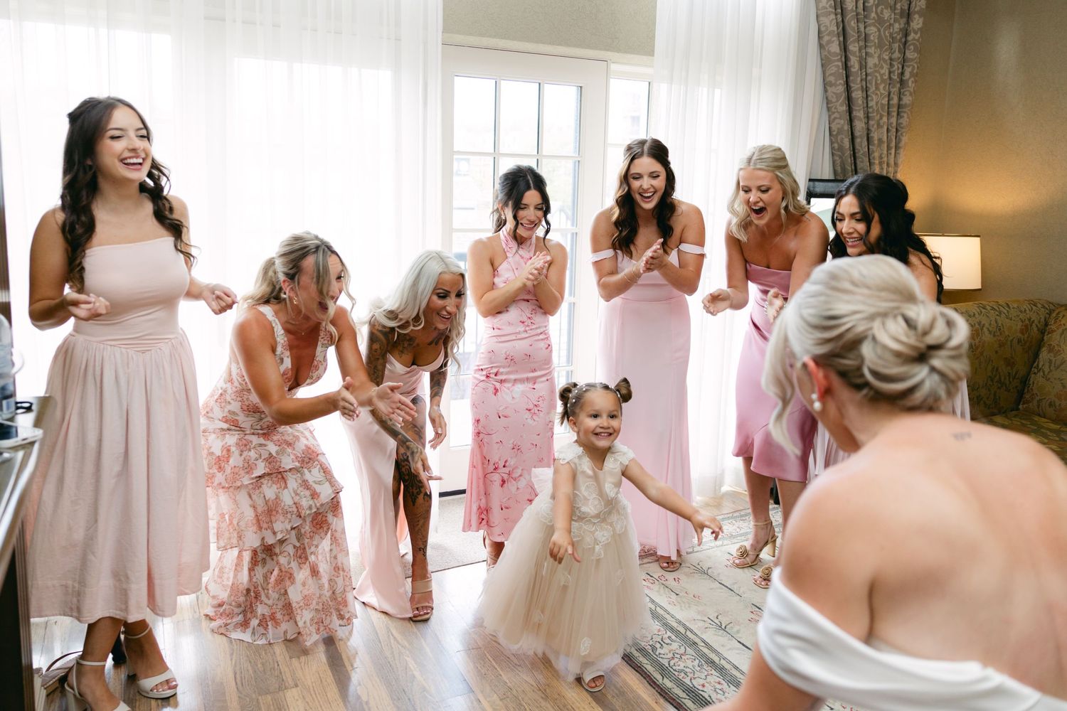 Candid getting ready moments with bridal party in pink and floral robes.