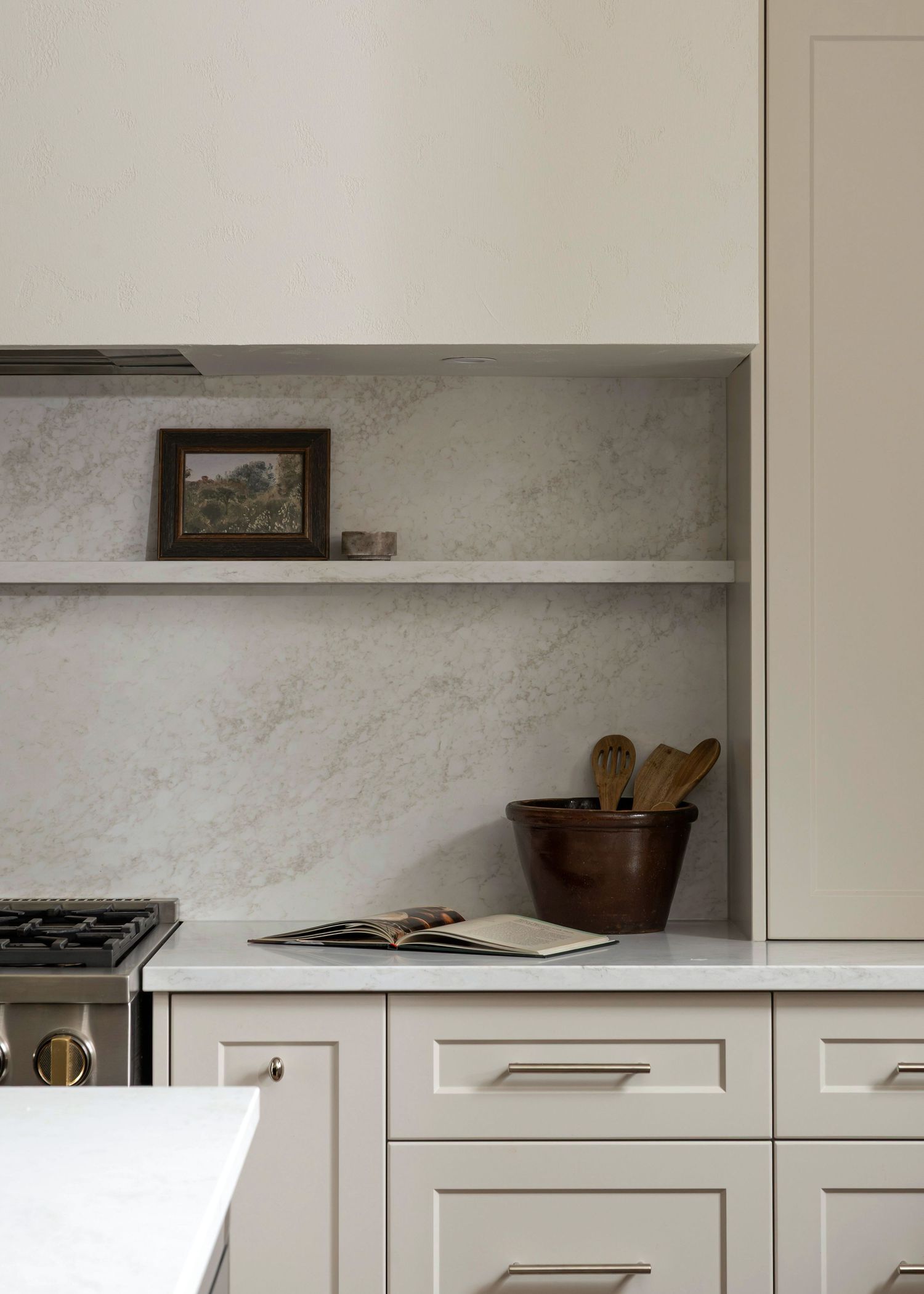 White kitchen cabinets with marble backsplash and minimalist hardware details.