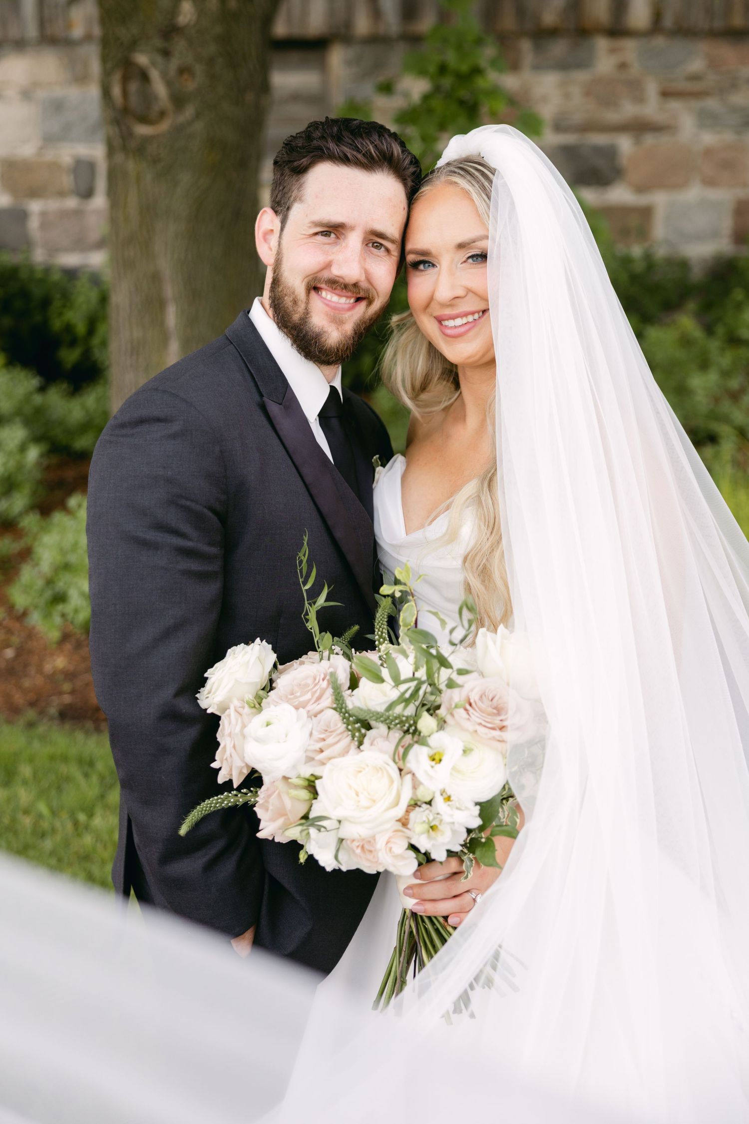 Newlyweds share intimate moments during outdoor wedding portraits.