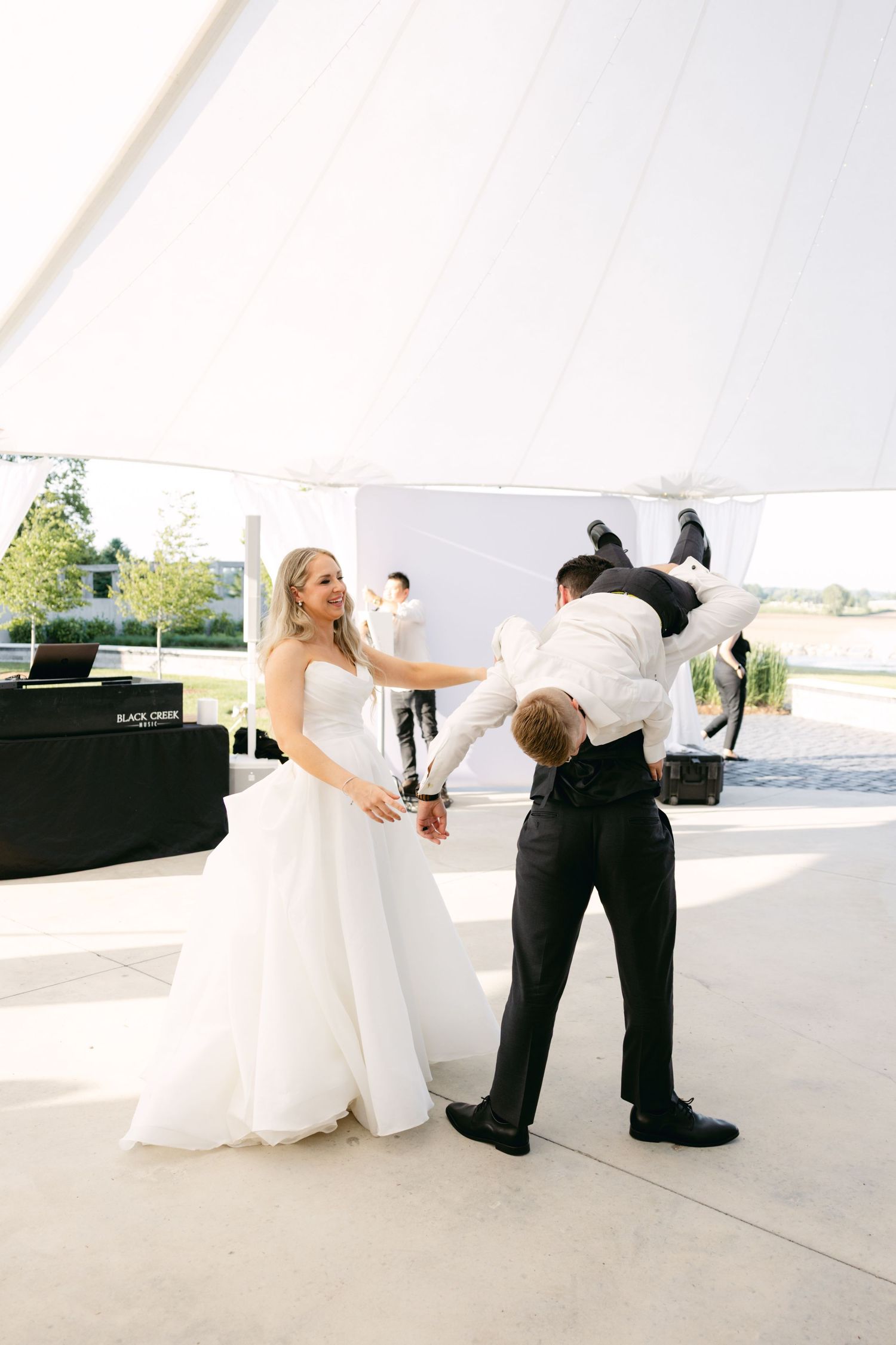 Wedding party members engage in playful poses during reception celebrations.