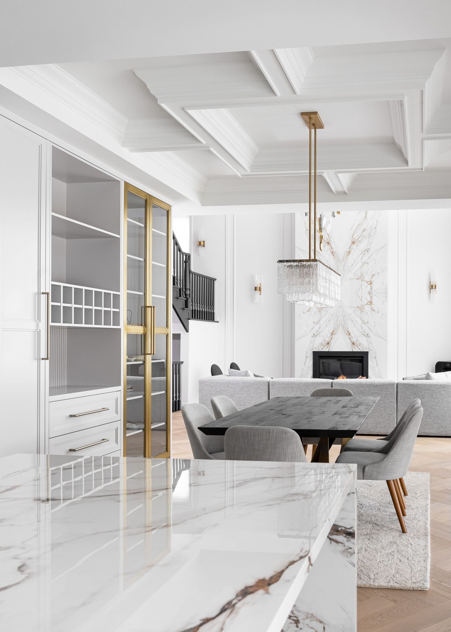 Modern open concept living room with white marble walls, coffered ceiling, and contemporary furniture.