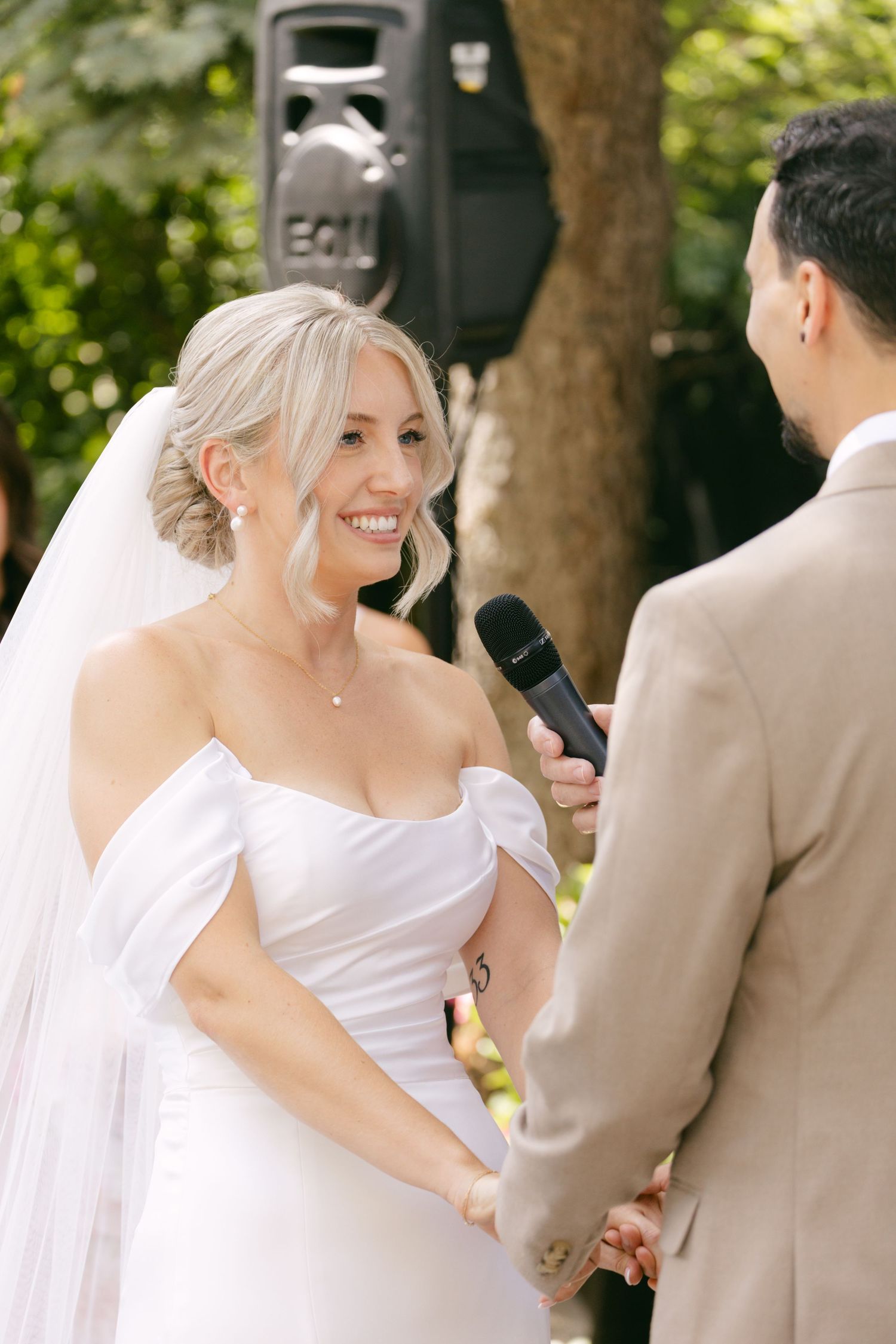 Joyful moments captured during outdoor wedding ceremony with natural garden backdrop.