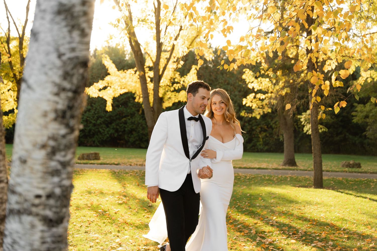 Autumn wedding photography session with couple among birch trees in evening light.