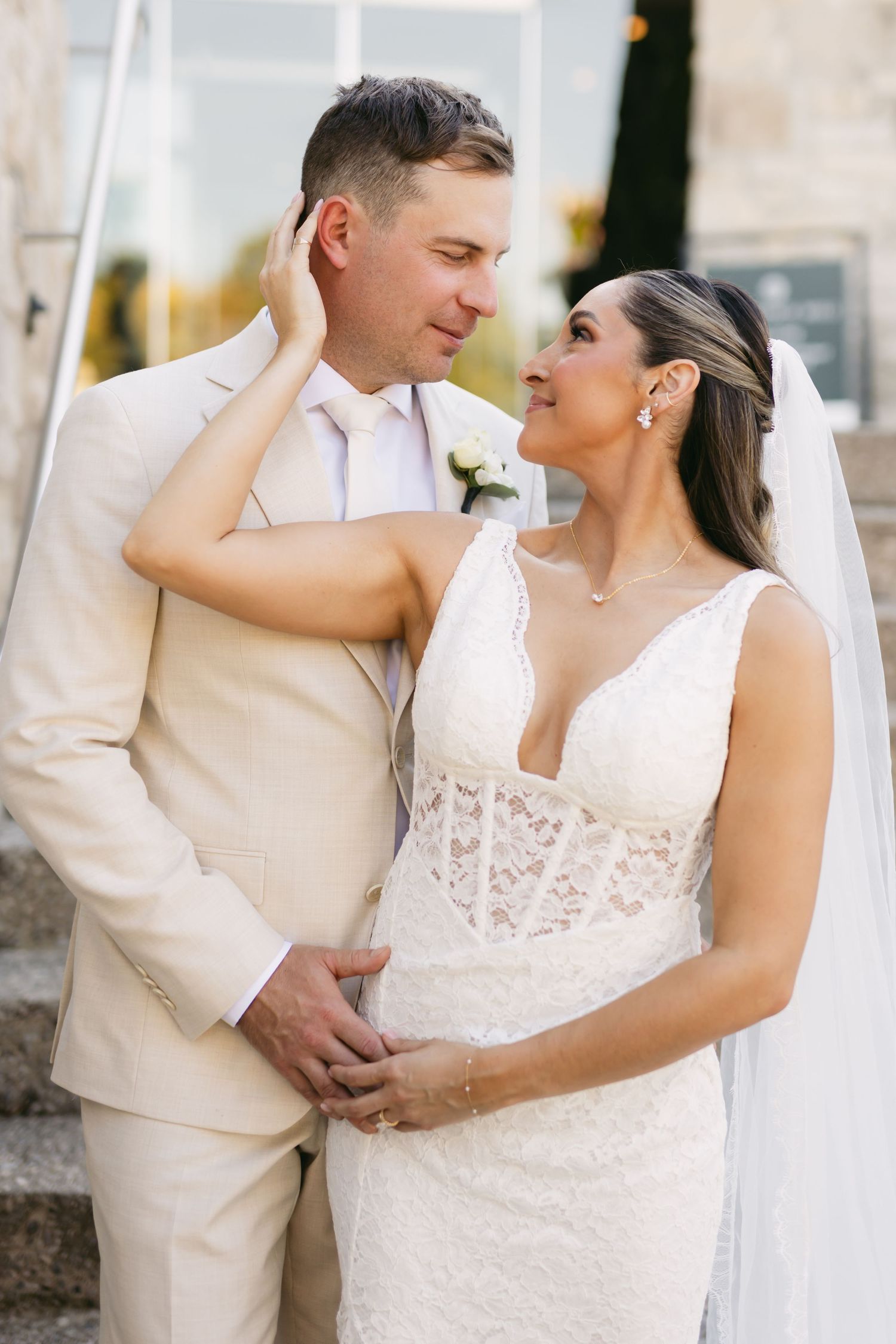 Romantic wedding portraits showcase a couple in cream and white attire embracing.