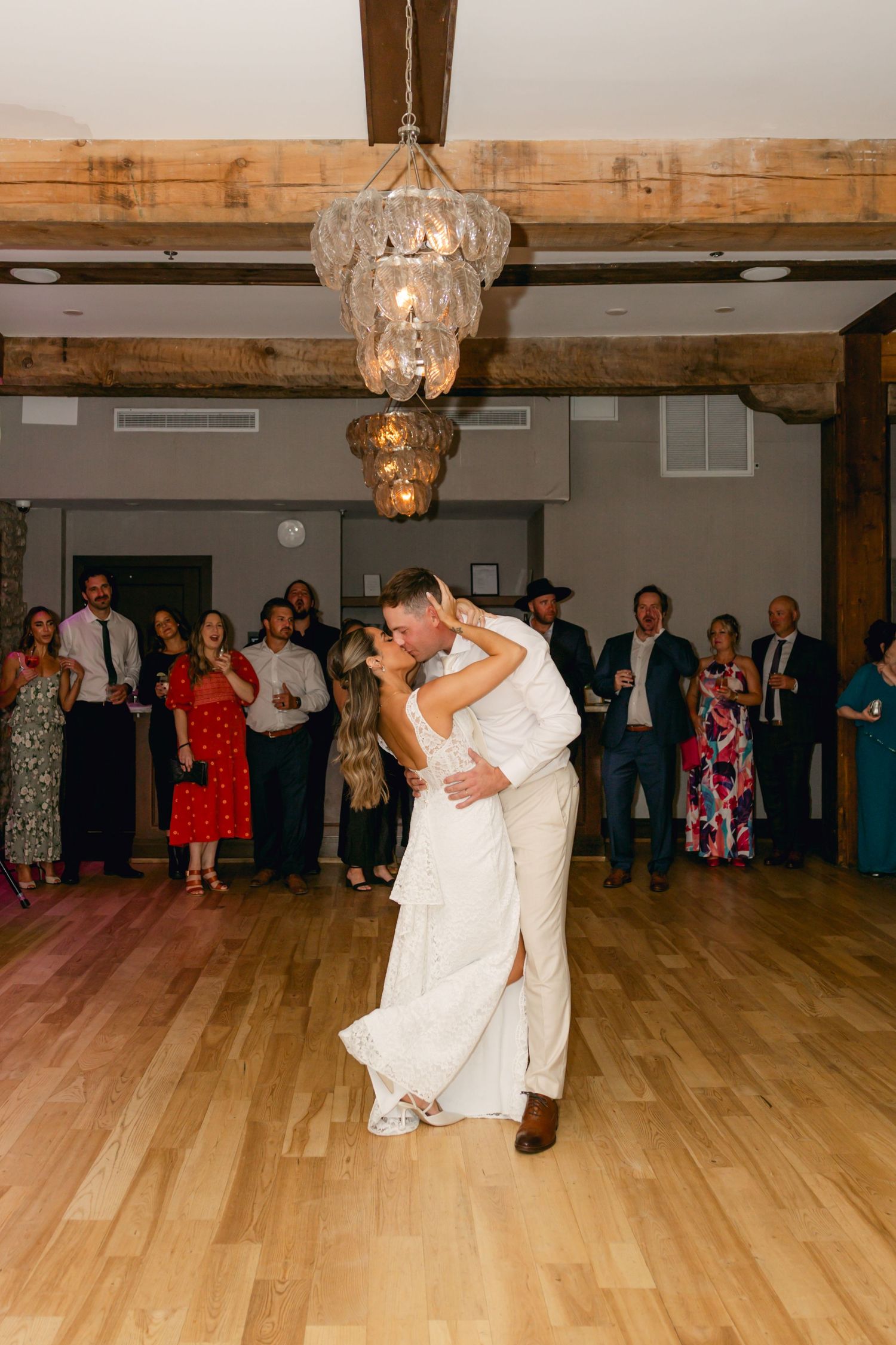 A couple performs a dramatic dance lift during their wedding reception.