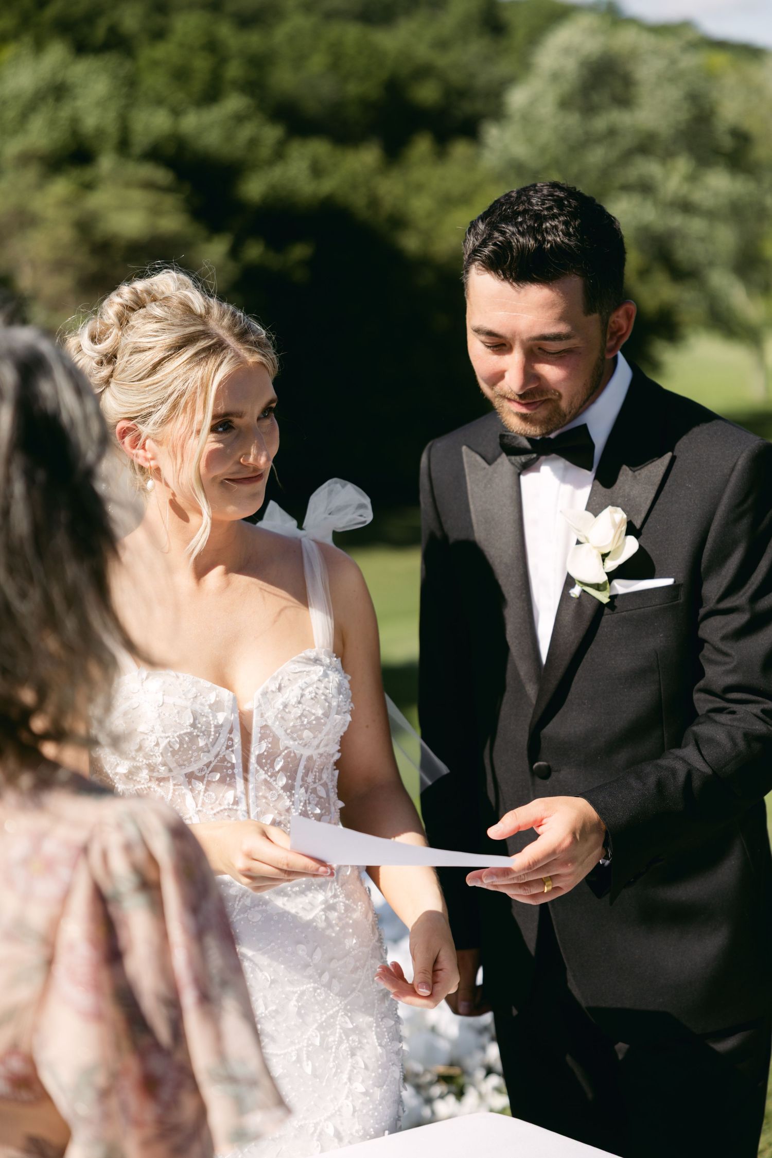 Couple exchanging vows during their outdoor wedding ceremony with beautiful natural lighting.