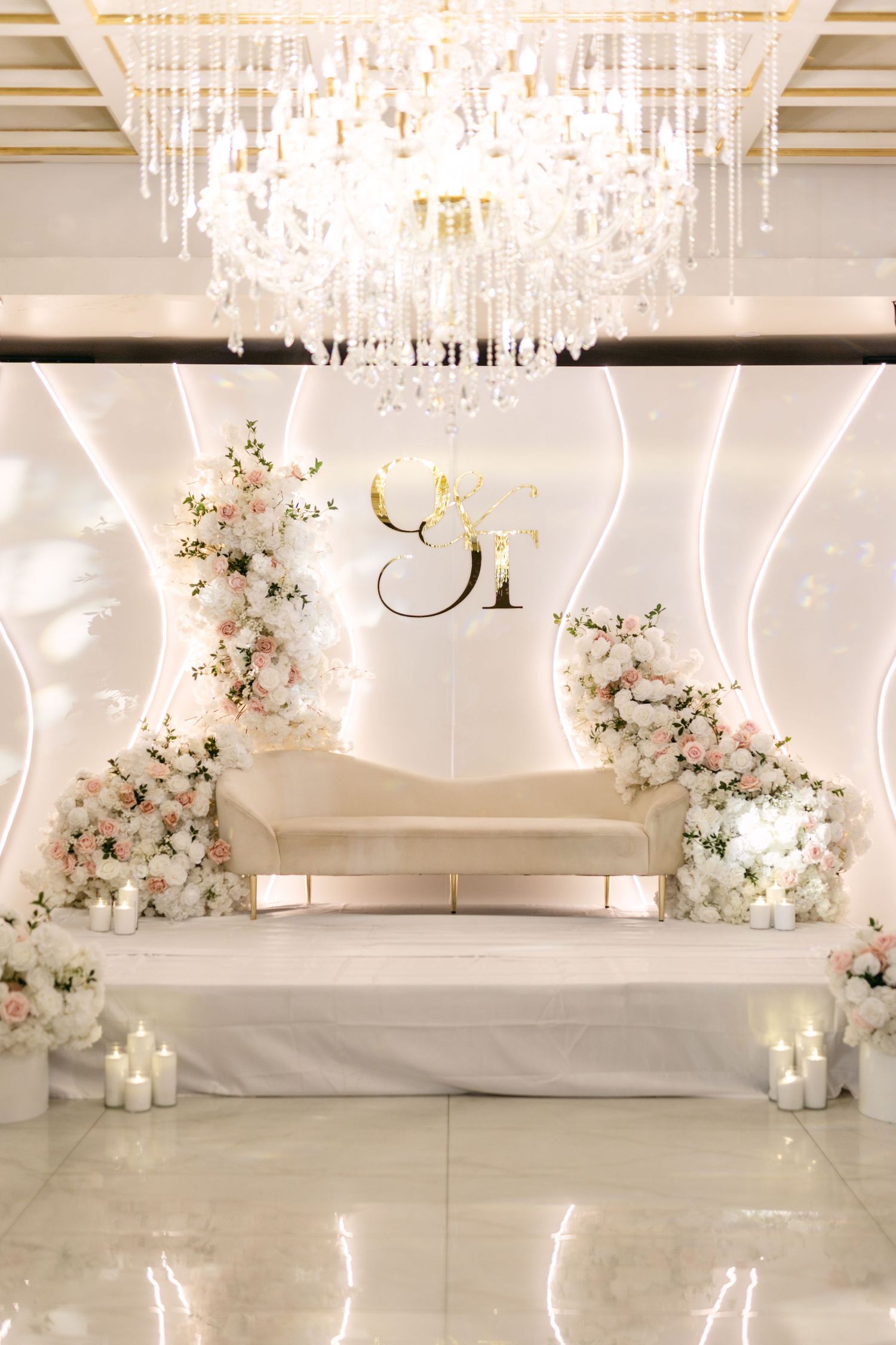 Elegant wedding reception space decorated with crystal chandeliers and soft floral arrangements.