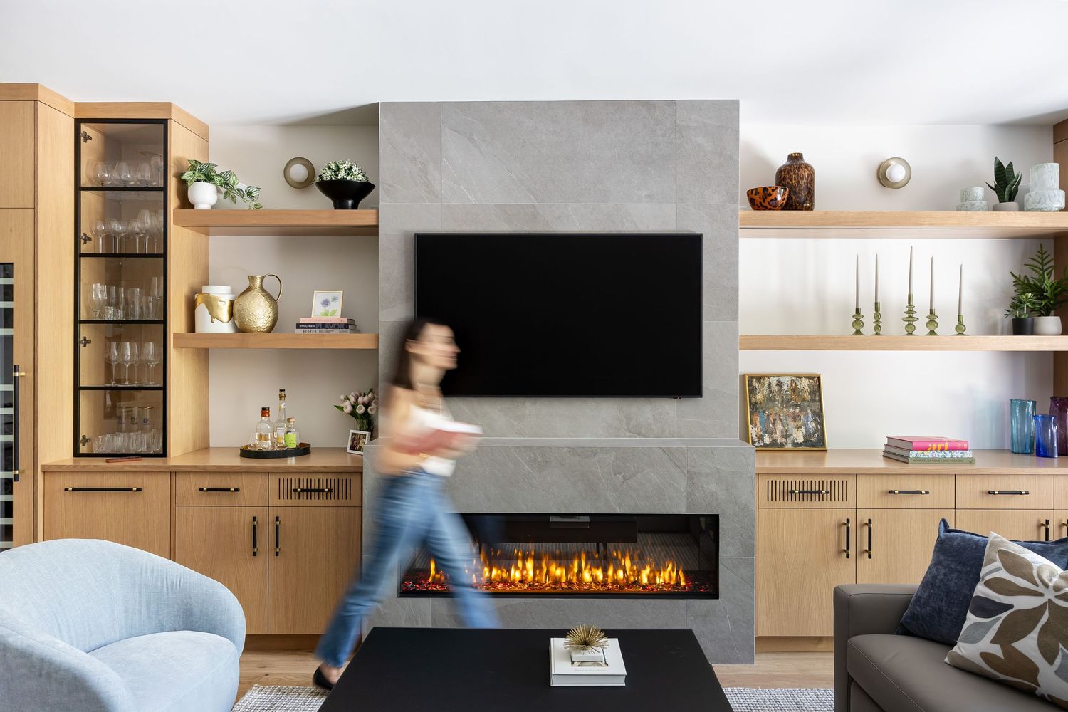 Living room with built-in storage, electric fireplace, and contemporary blue accent chair.