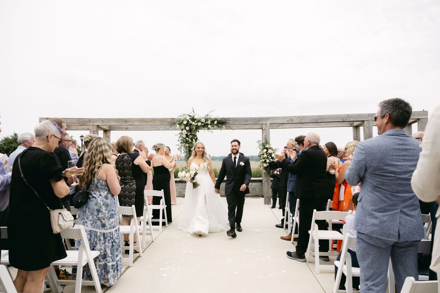 Wedding reception guests dancing and celebrating on an outdoor patio.