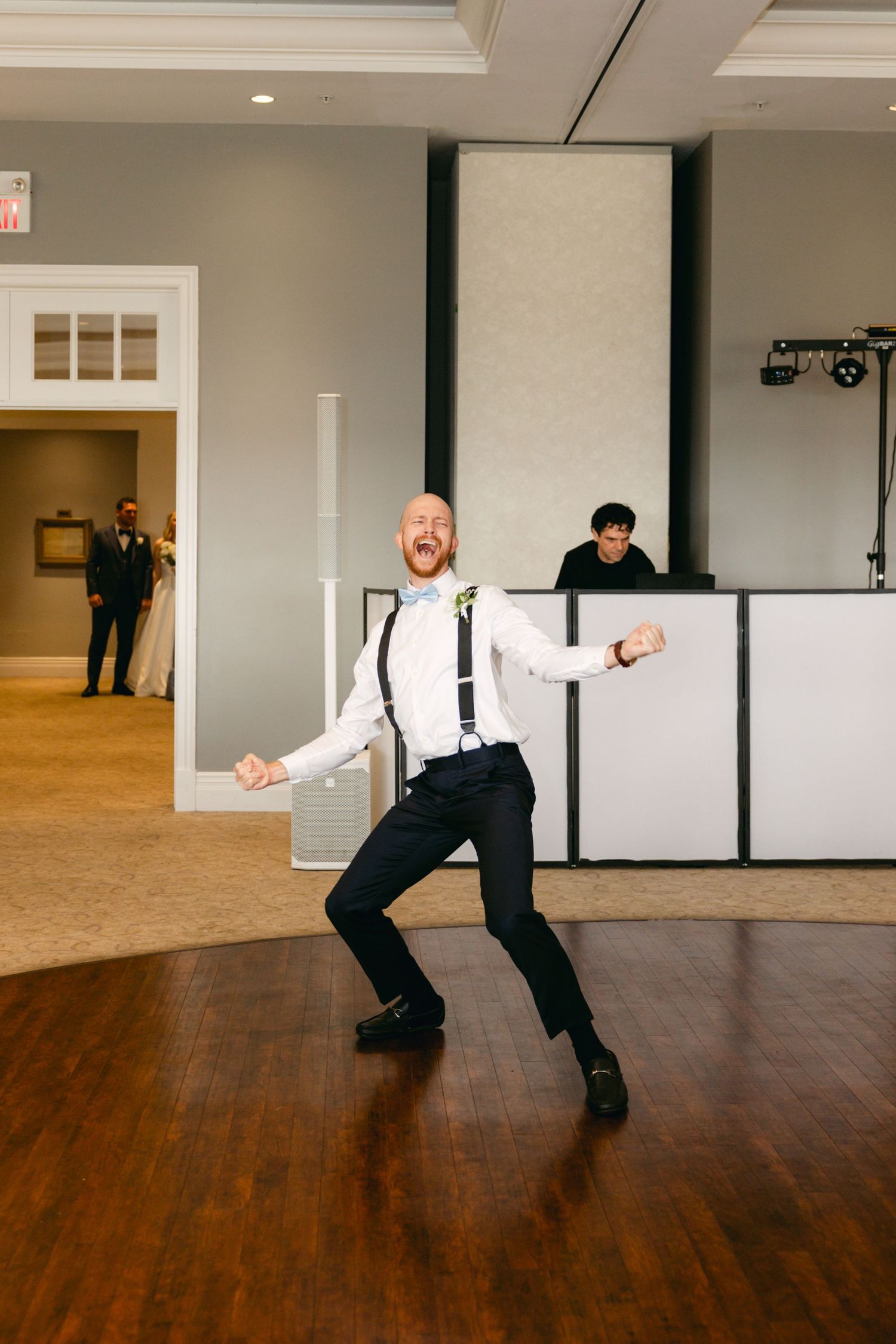 Series of dramatic dance moves performed on hardwood floor at wedding reception.