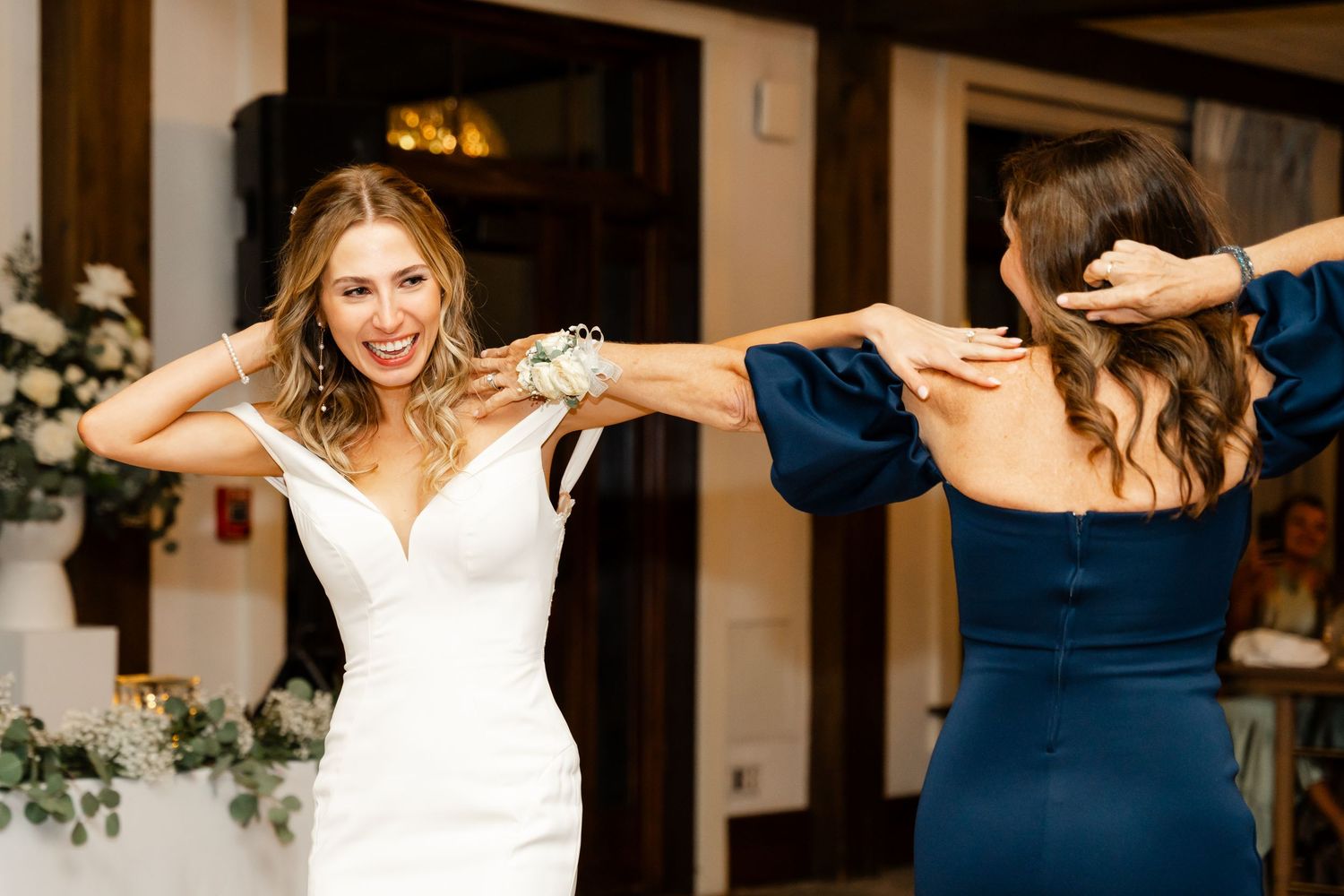 Bride and groom share playful moments during their wedding photo session in an elegant indoor venue.