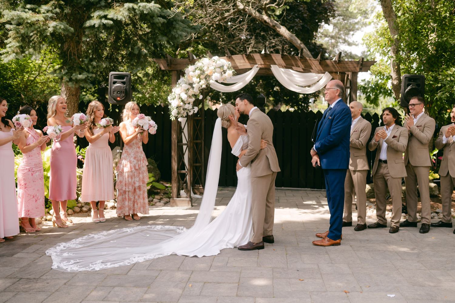 Wedding celebration sequence showing joyful reactions from the wedding party on an outdoor patio.