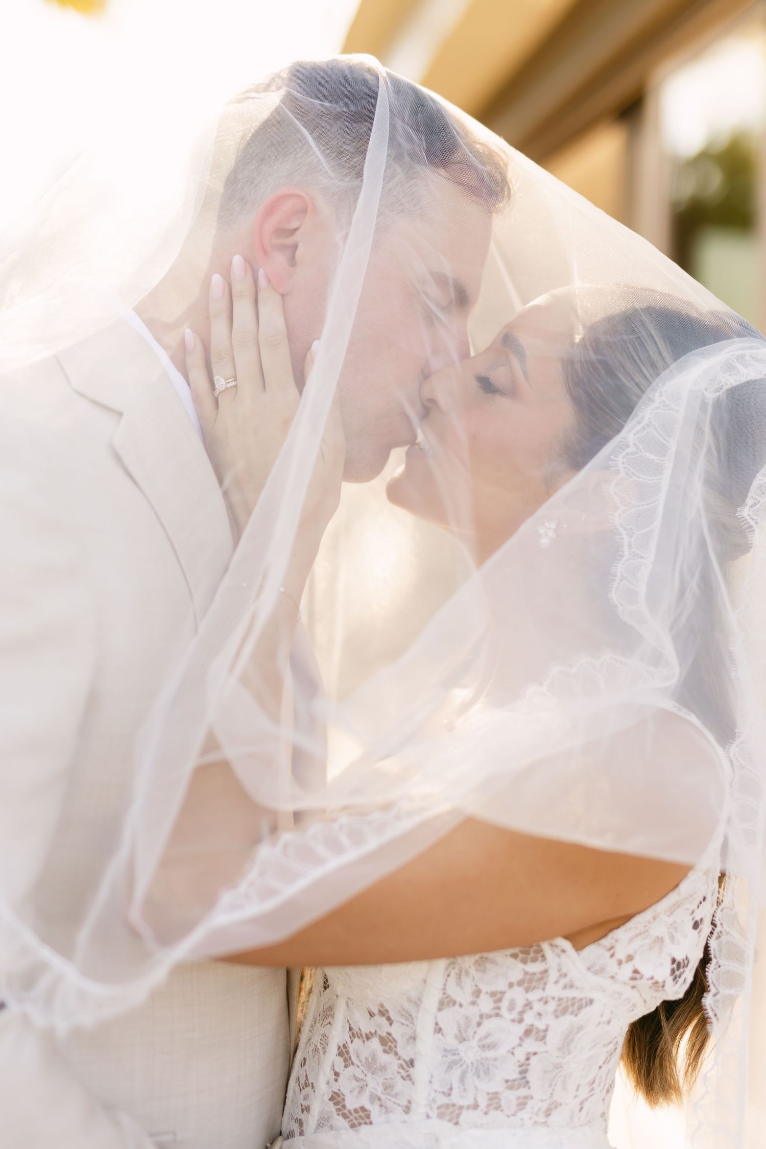 Romantic wedding portrait with couple sharing an intimate moment under a delicate veil.
