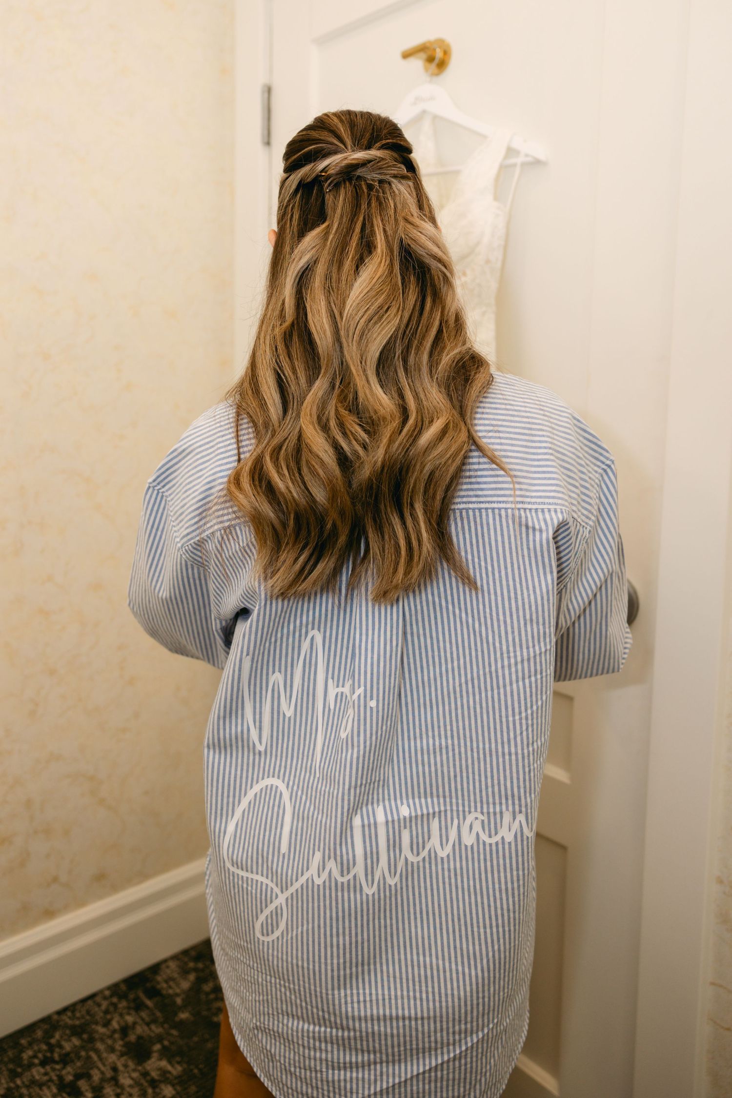 Blue and white striped button-down shirt with text shown from behind.