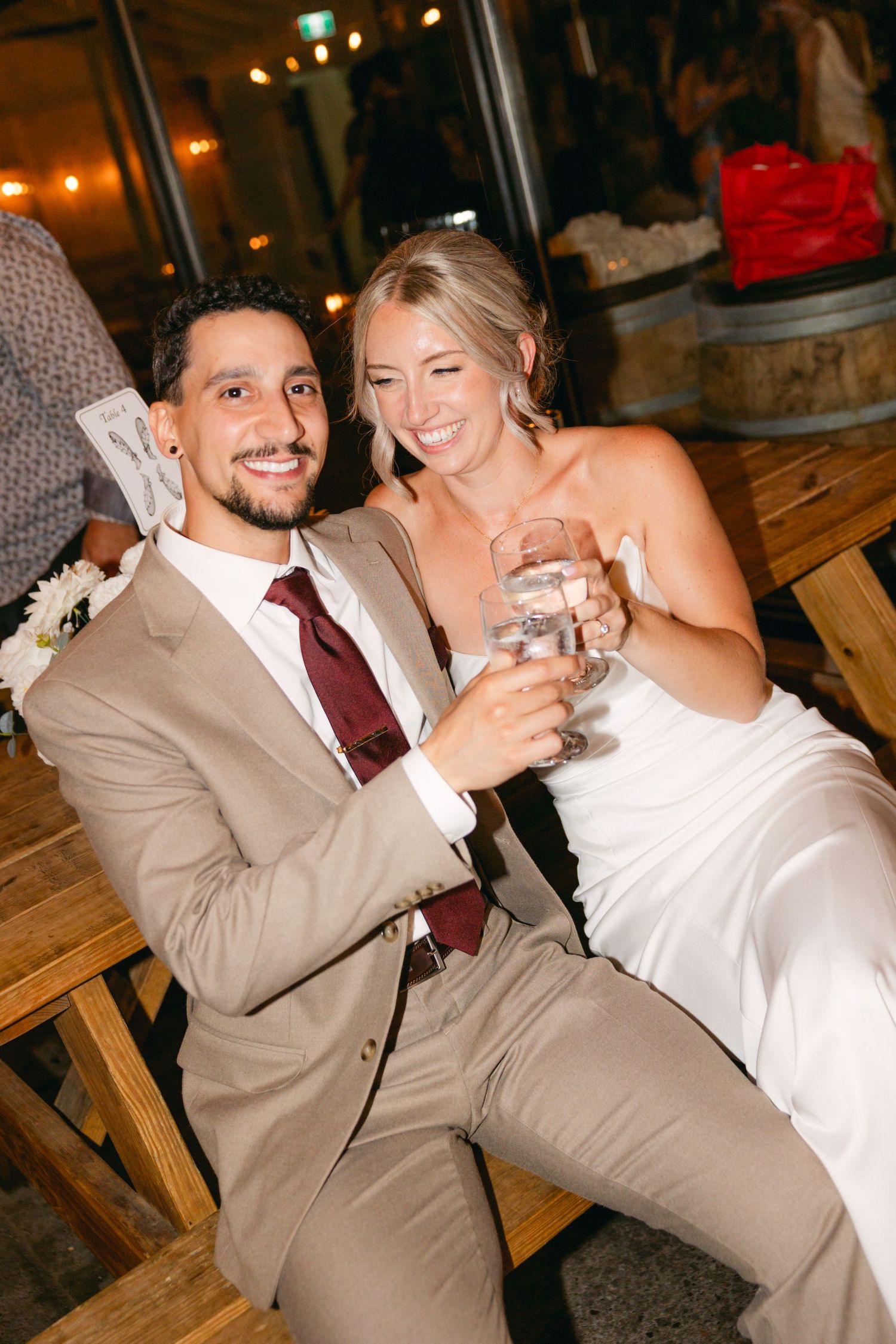 Celebratory moment at wedding reception with couple enjoying drinks.