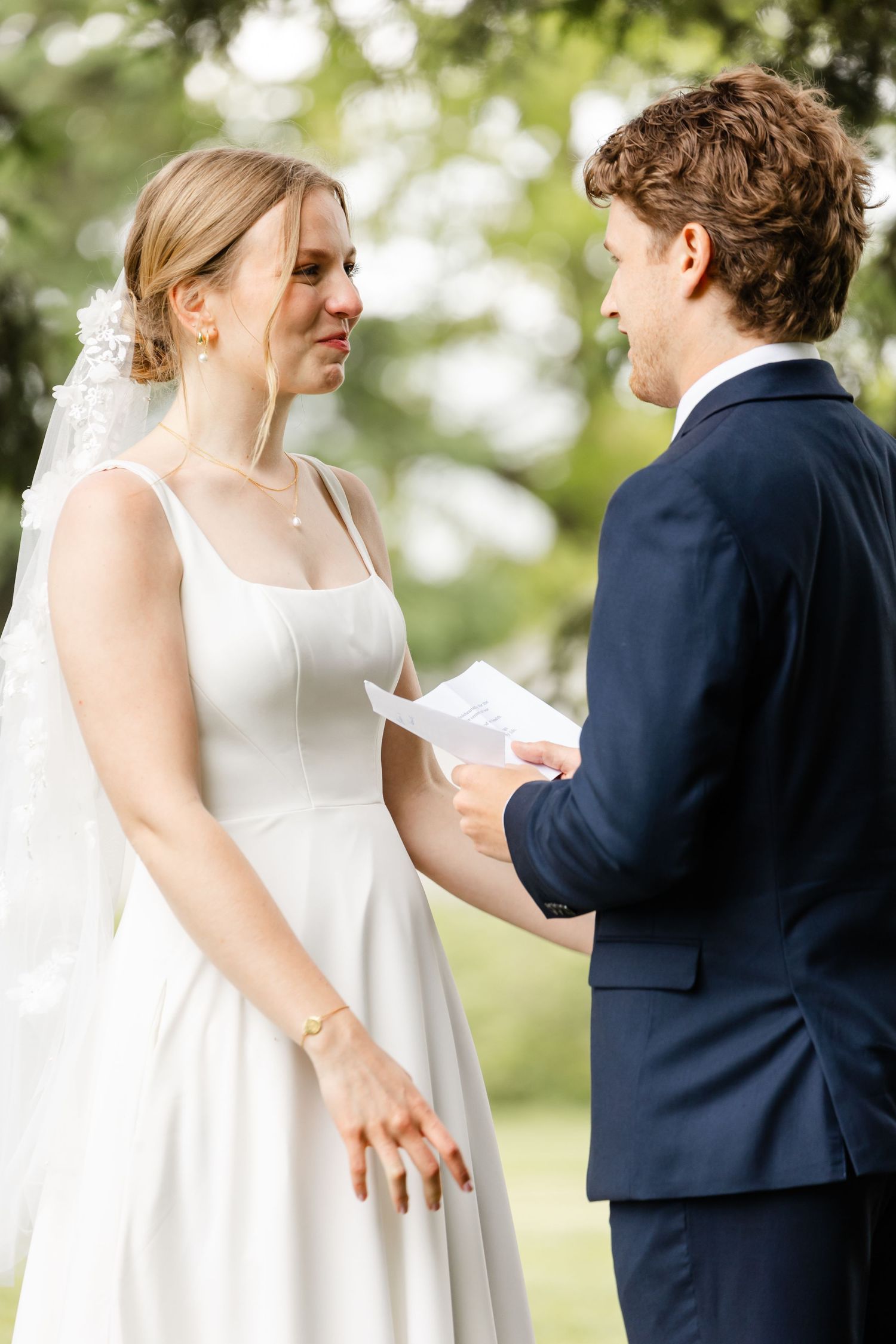 Couple shares intimate moment while reading letters during outdoor first look.