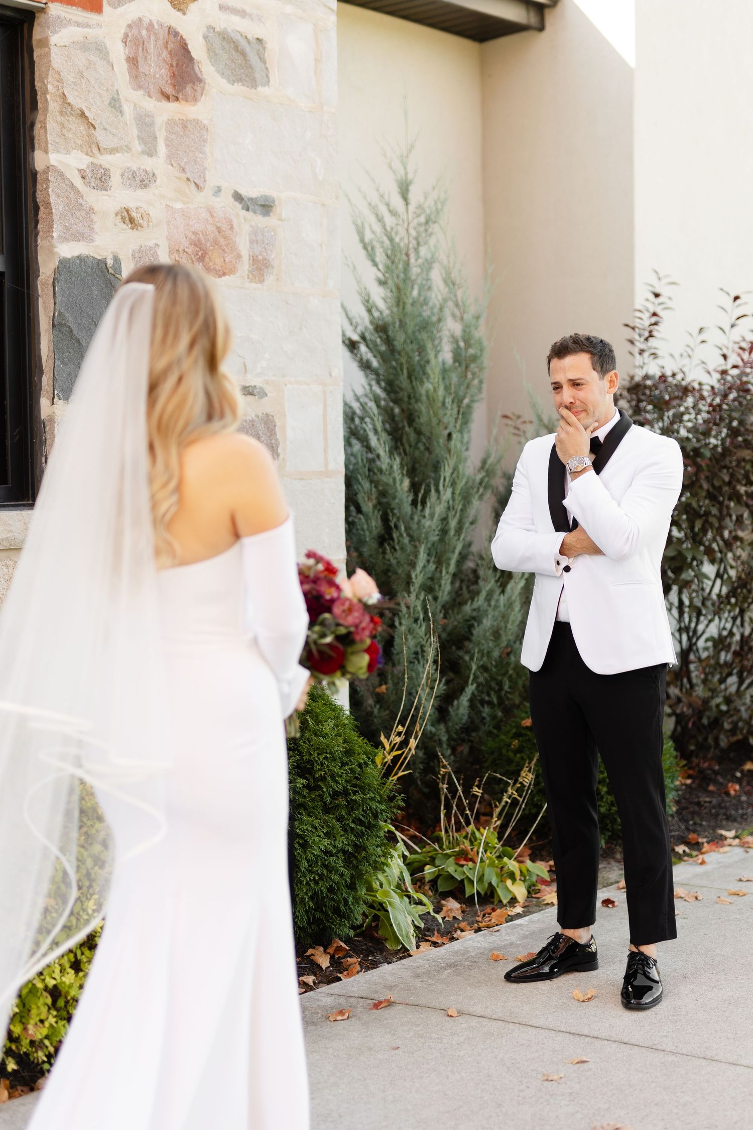 A wedding first look sequence showing a bride walking up to her groom at a stone venue.