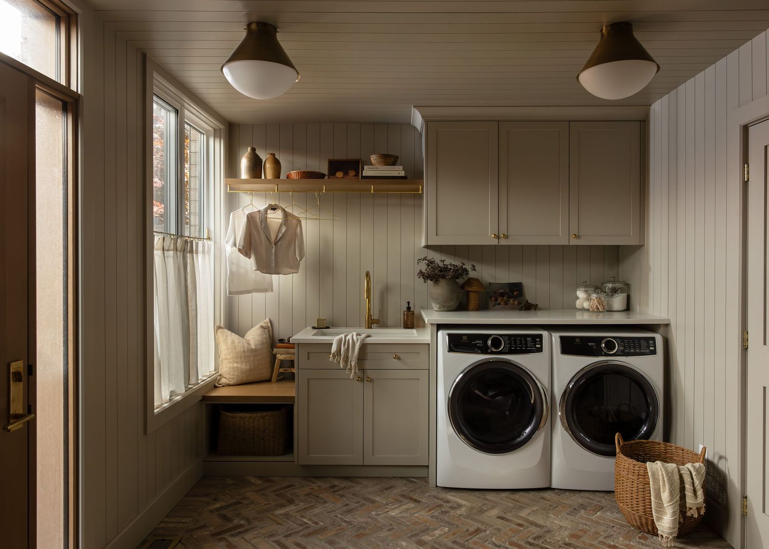 Spacious laundry room features white shaker cabinets and modern appliances.