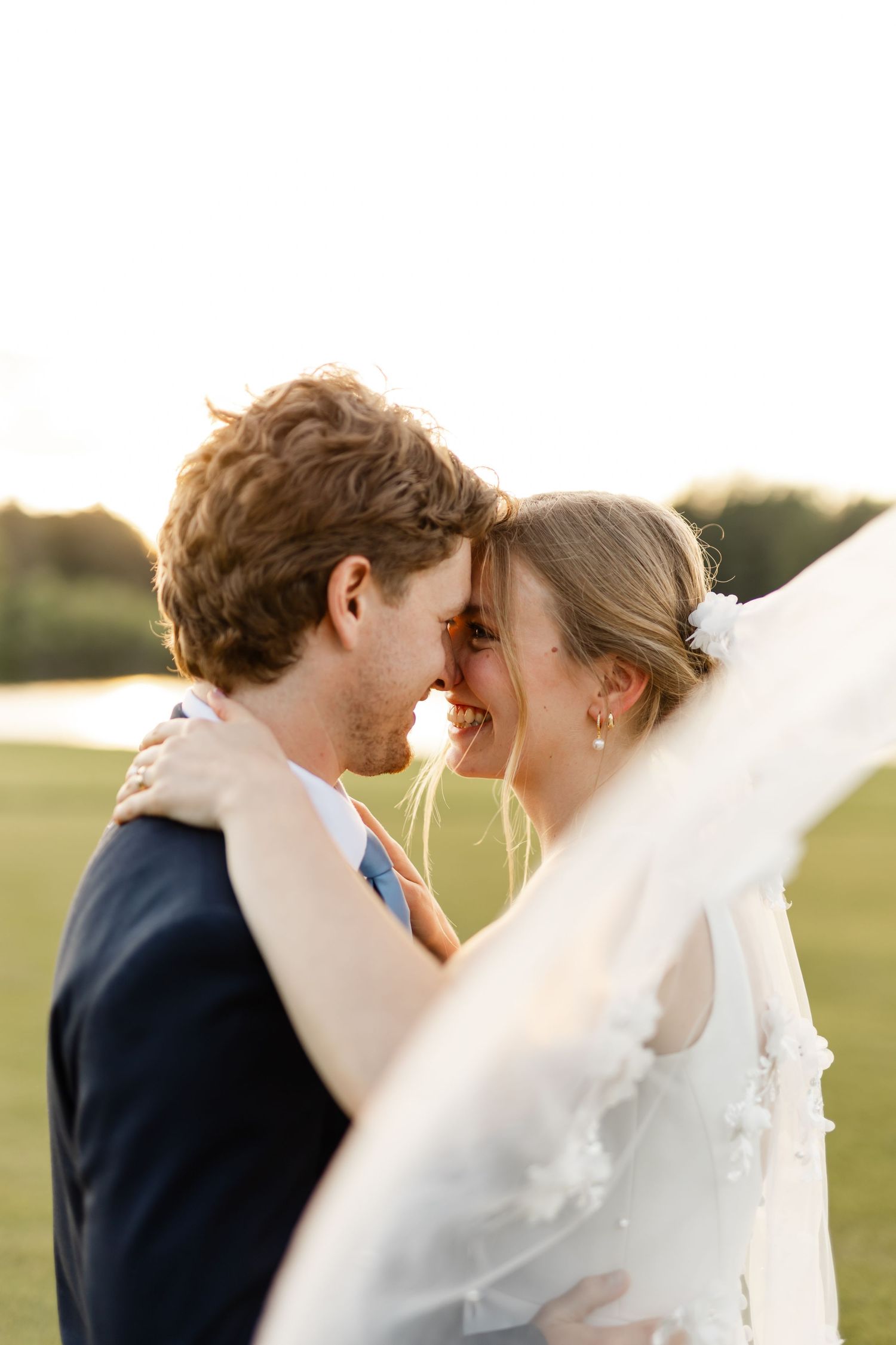 An intimate portrait of a couple sharing a close embrace outdoors.