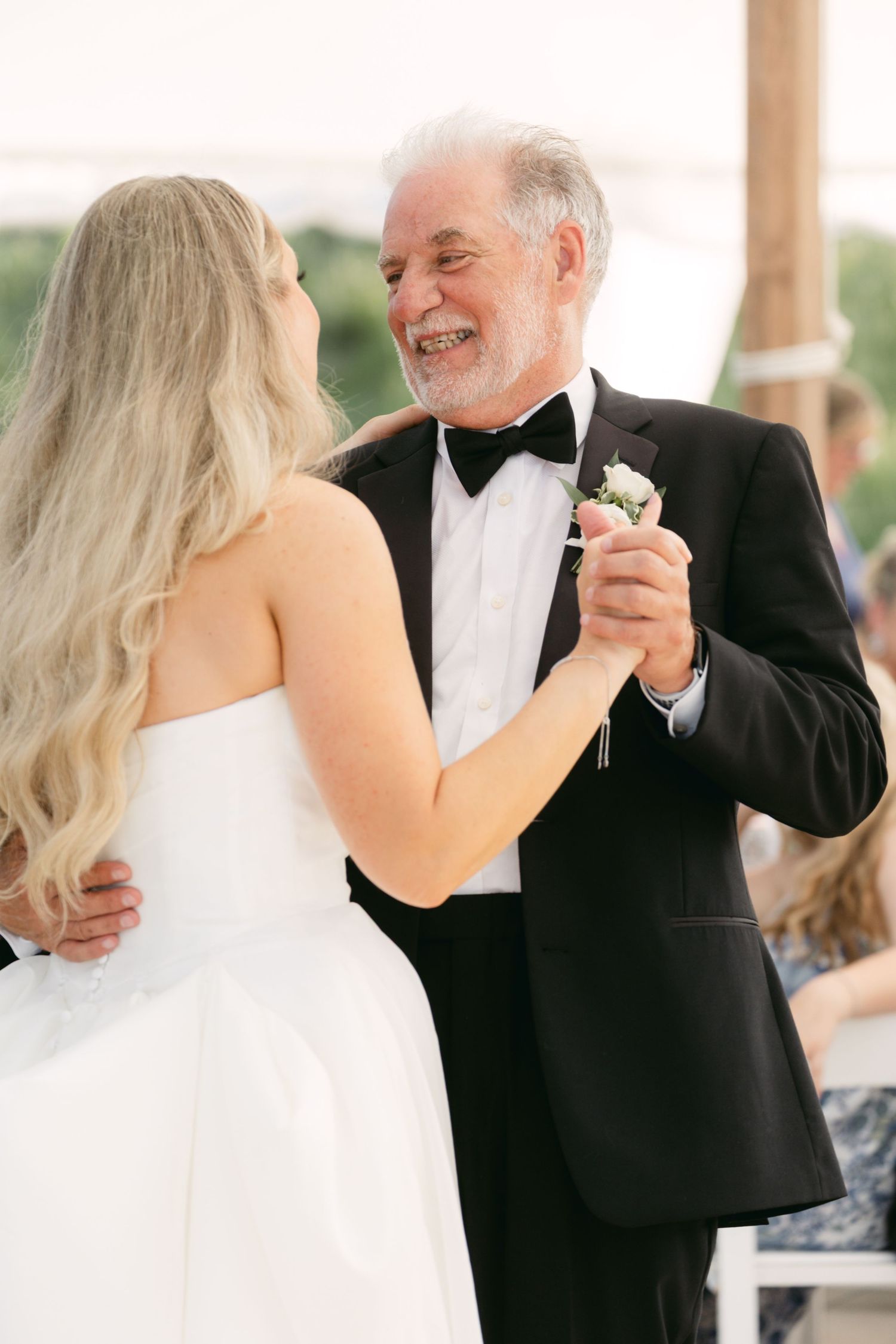 Elegant dance shared during wedding reception under white tent.