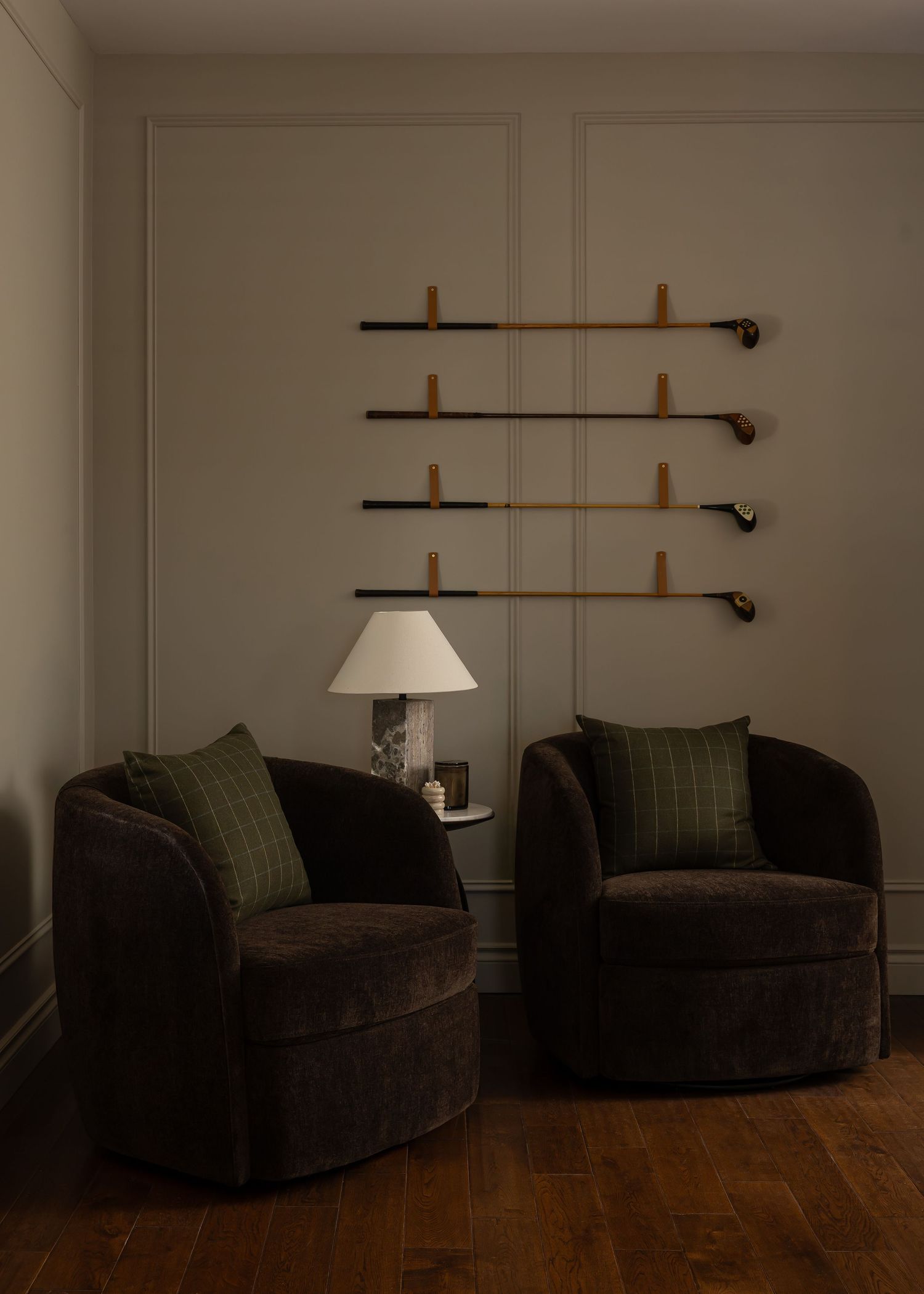 Cozy seating area with dark velvet sofa and wall-mounted sconce lighting.