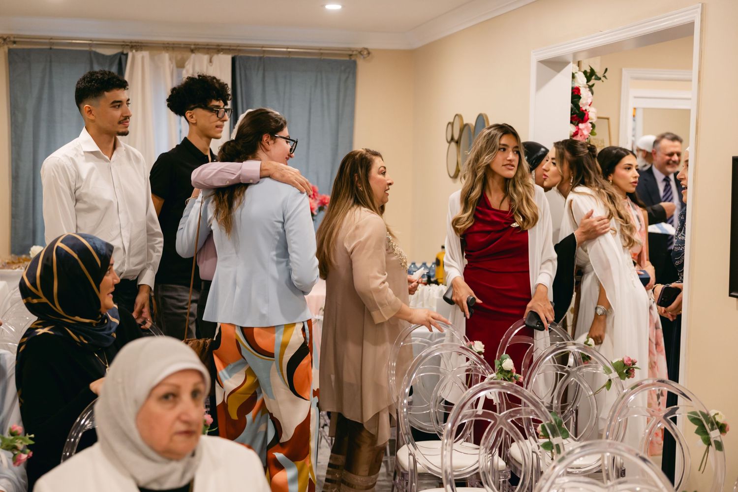 People mingling in a bright indoor space during a formal gathering.