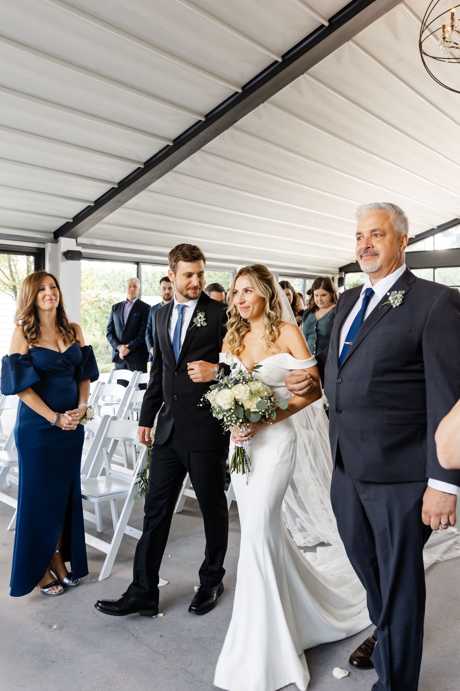 Wedding party walking in procession under covered outdoor venue.