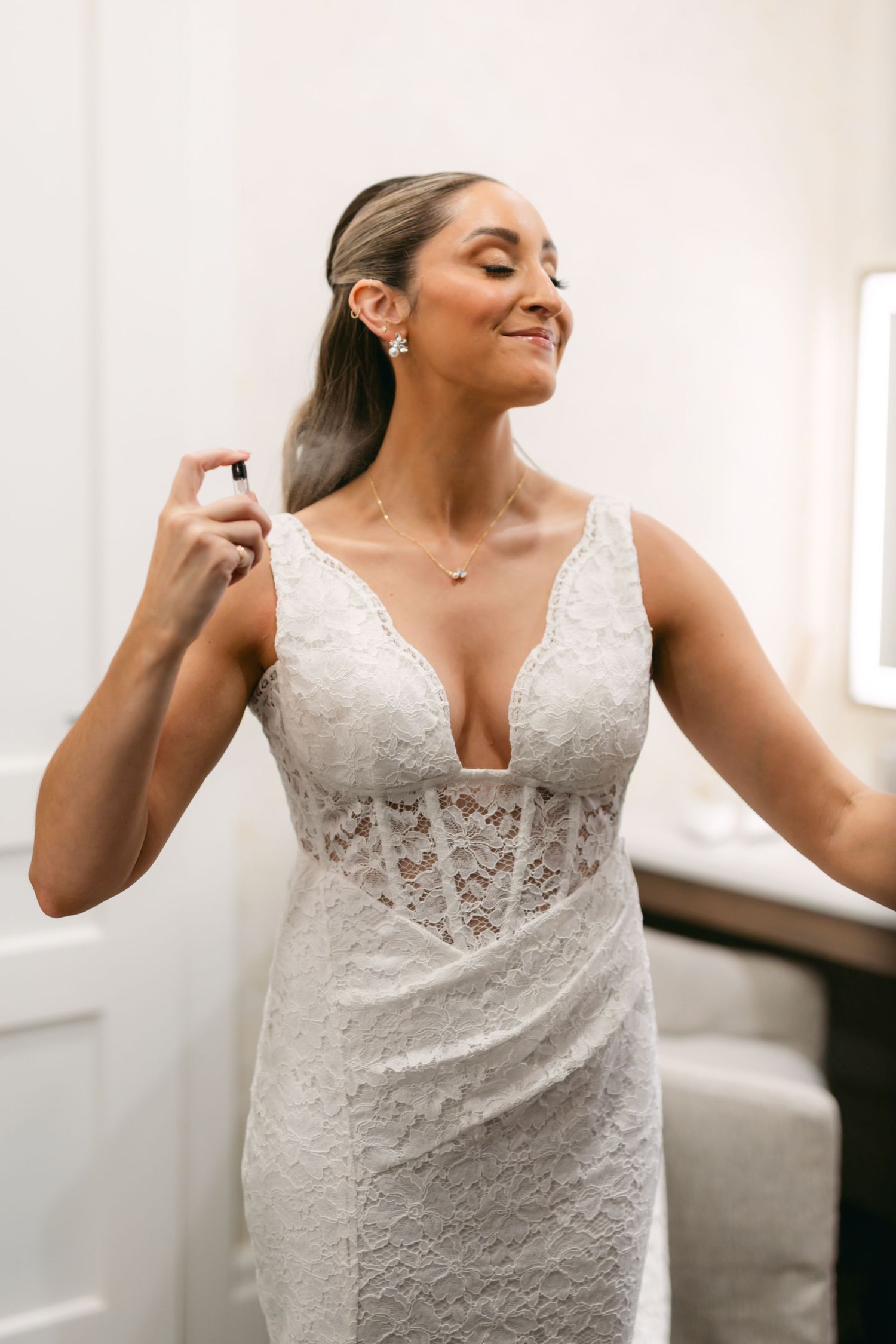 Close-up details of a stunning white lace wedding dress on a figure.