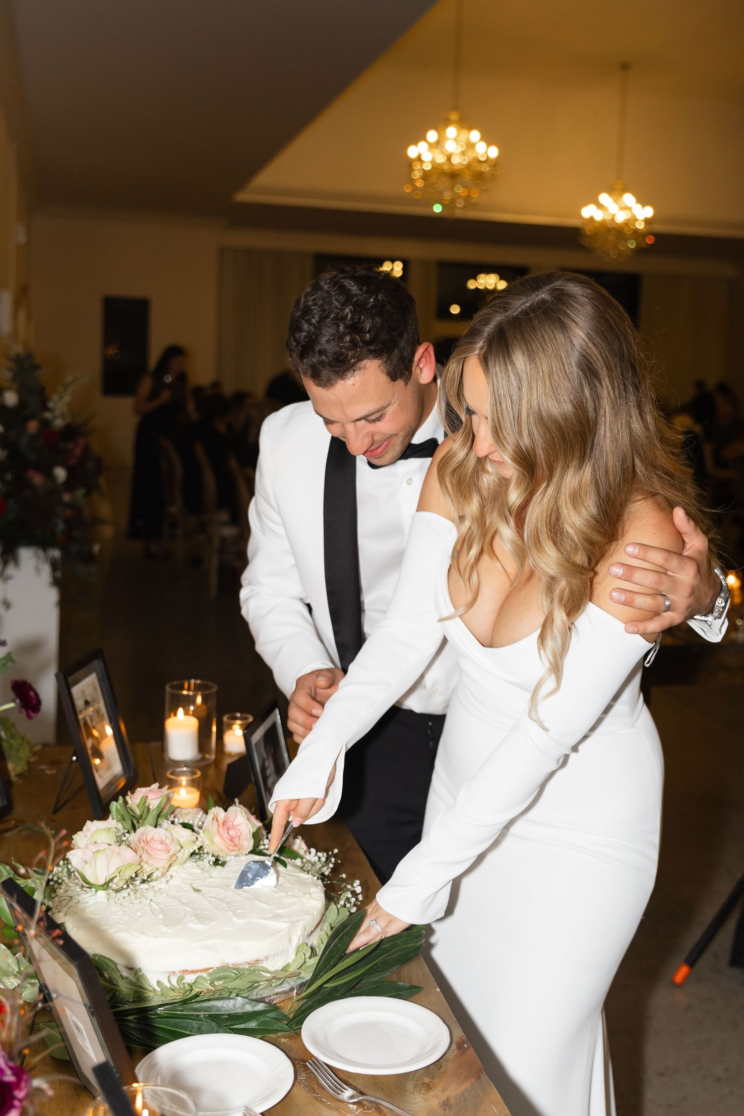 Couple cutting their wedding cake together during the reception celebration.