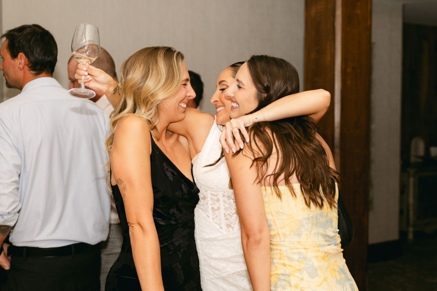Wedding guests dancing and celebrating at reception with rustic decor.