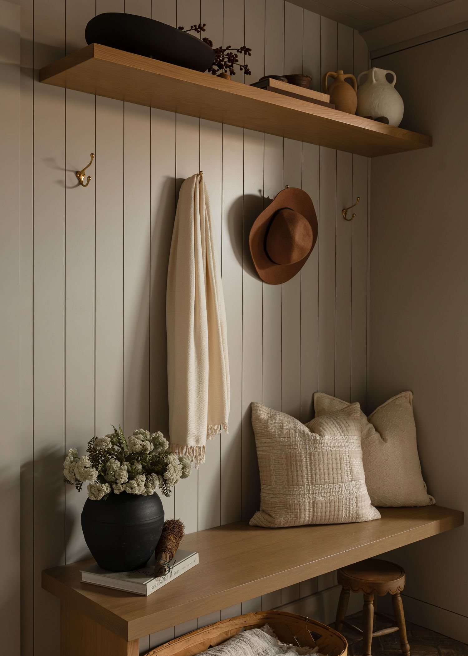 Rustic modern mudroom with wooden shelving, white shiplap walls, and neutral decor accents.
