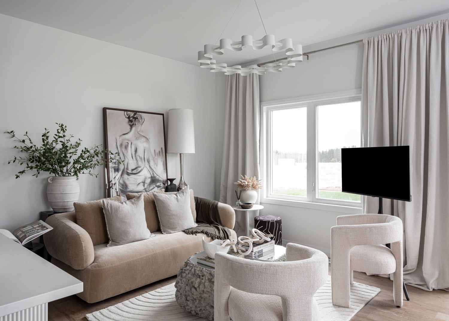 Bright living room with neutral color palette, modern furniture and large windows.