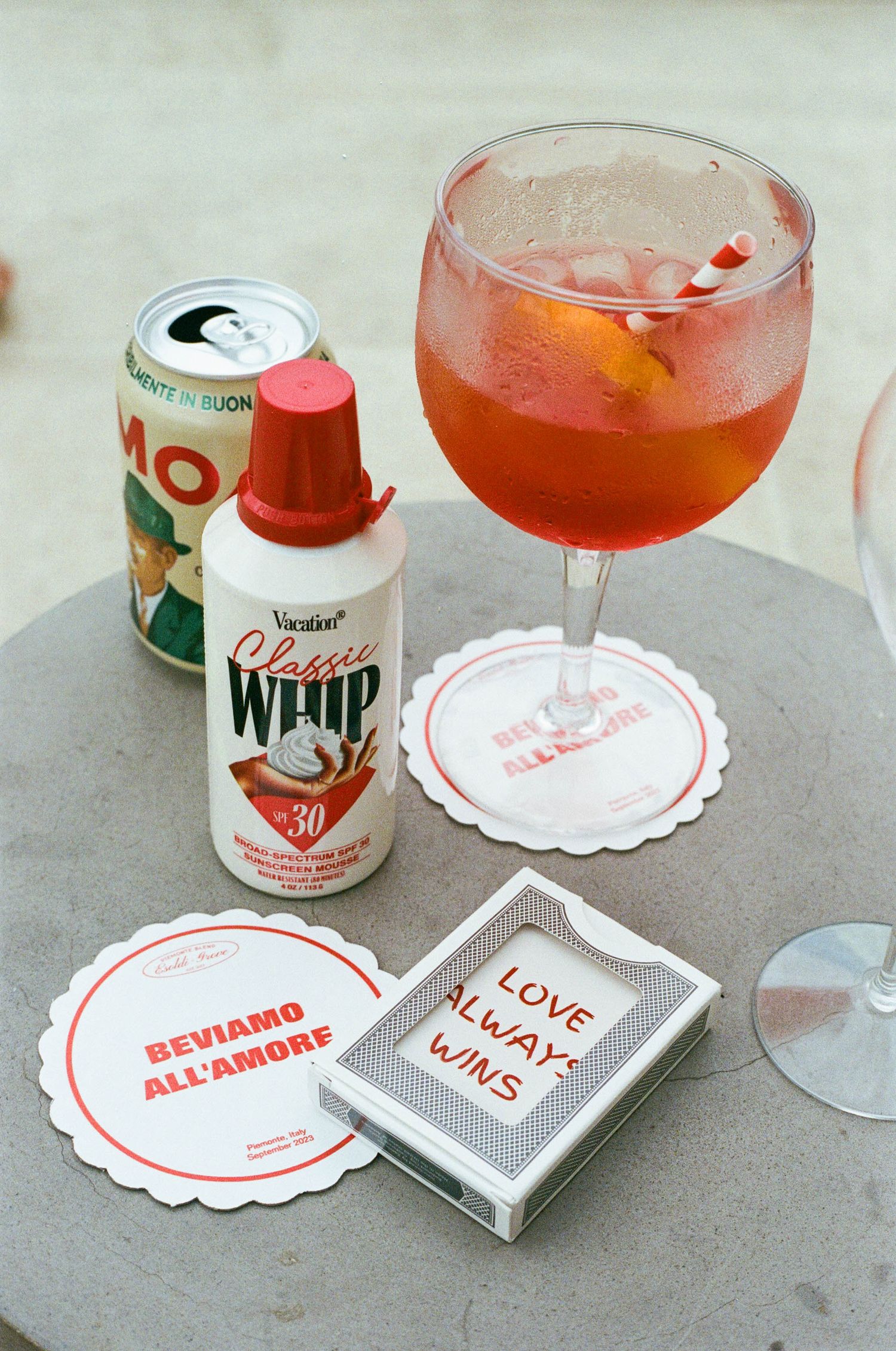 Pink cocktails and custom wedding coasters with love messages on a gray surface.