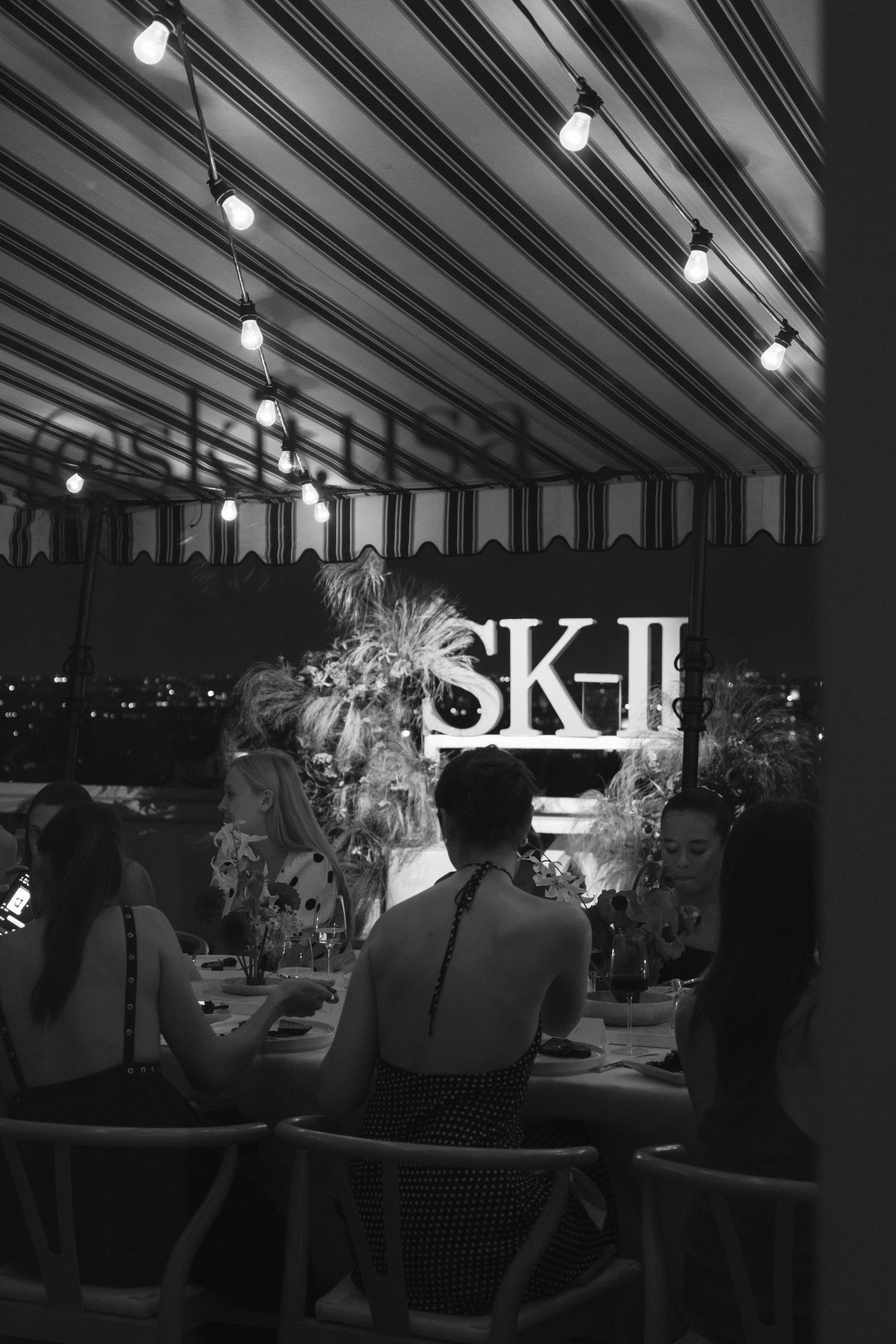 Black and white photo of an SK-II branded event under striped lighting.