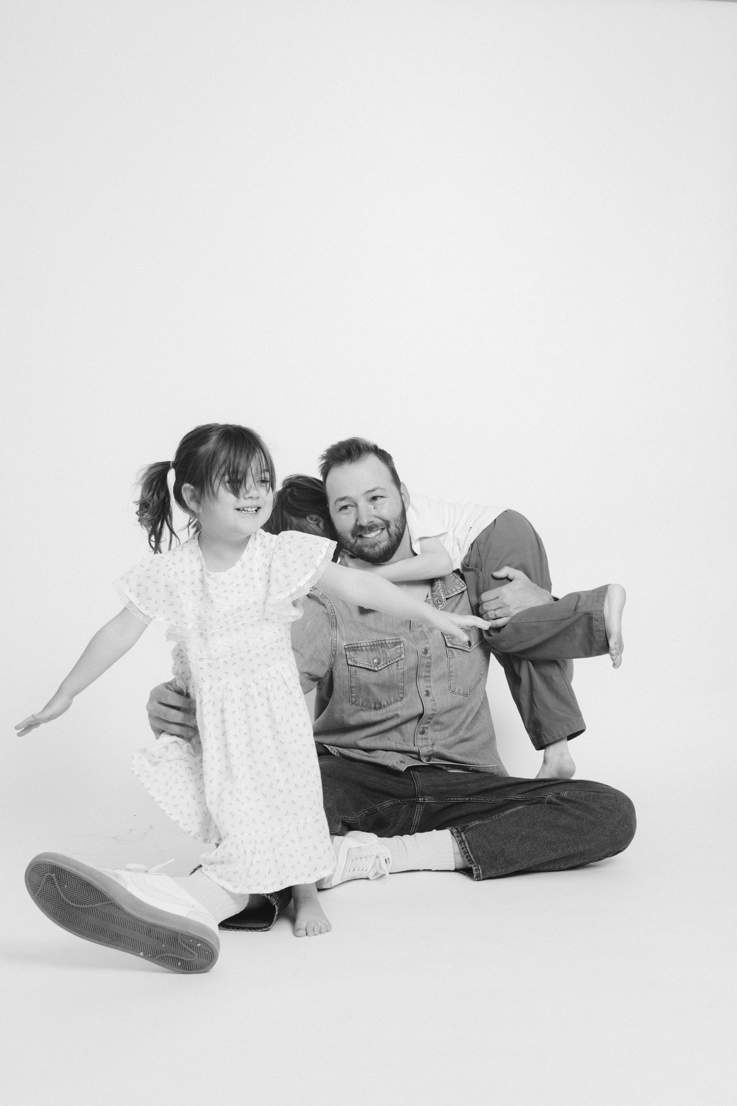 Black and white photos on white background showing playful family interactions.