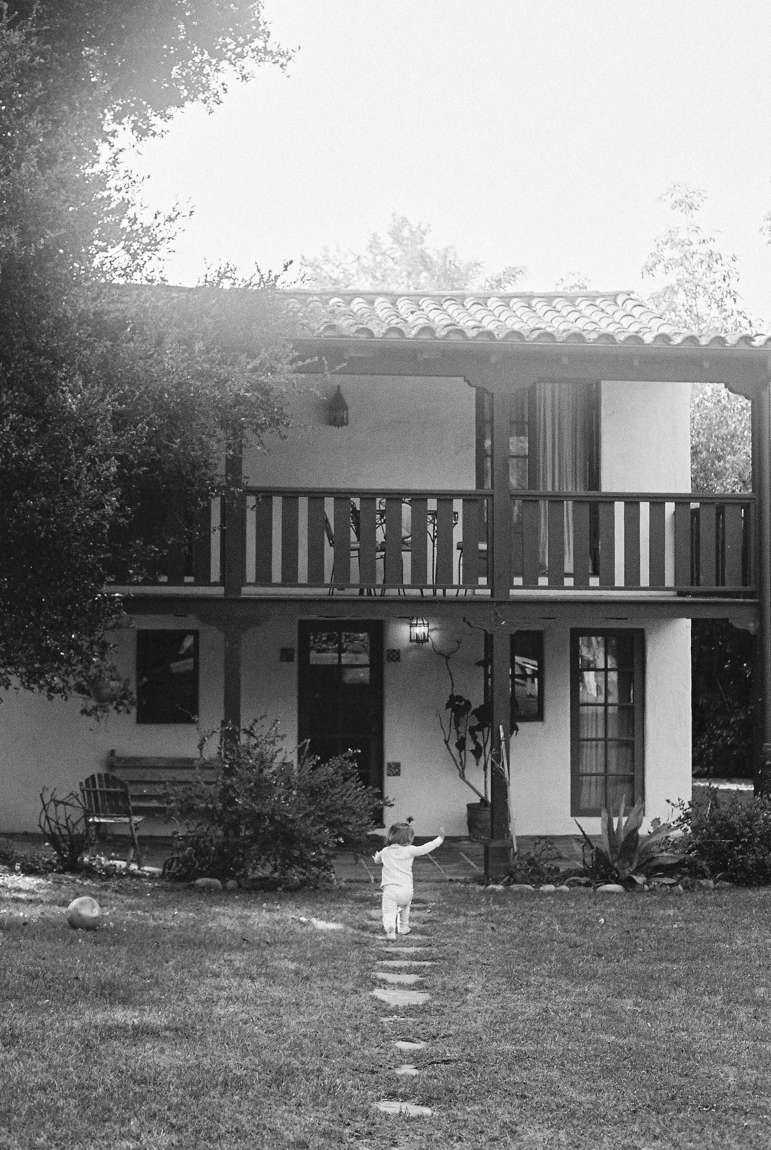 Black and white exterior view of a mid-century modern house with covered porch.