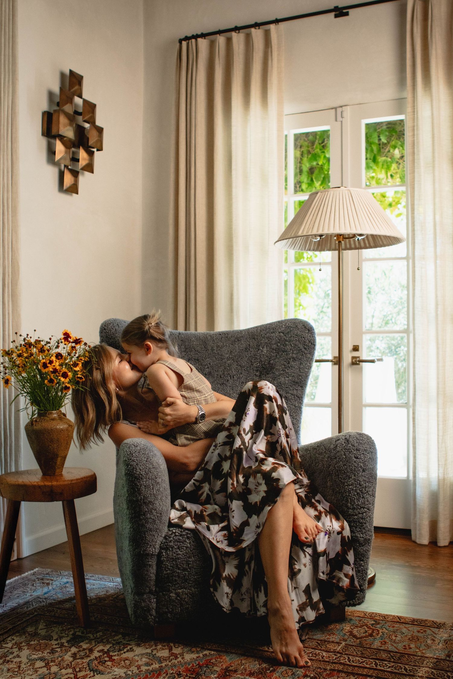 Romantic couple relaxing together on grey couch in sunlit living room.