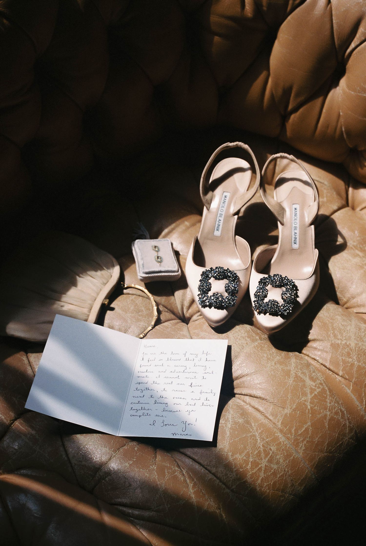 Elegant black and white bridal shoes with embellishments displayed next to a handwritten note.