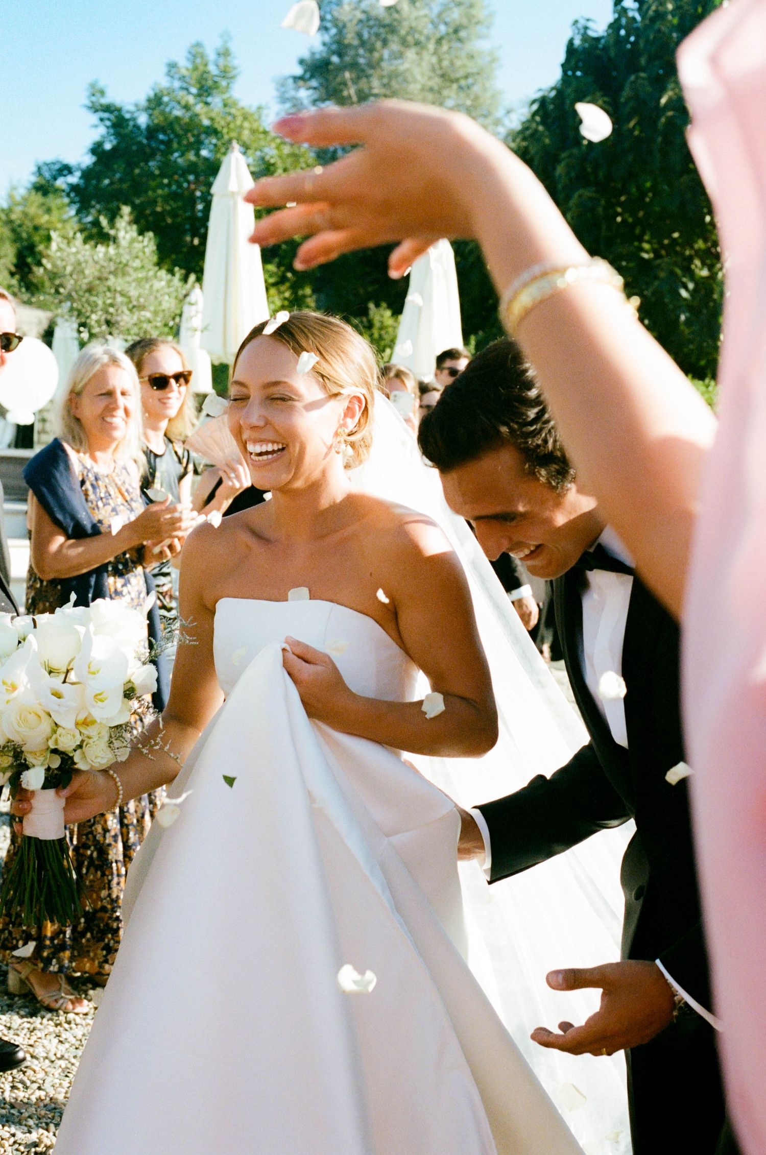 Wedding party celebrating and dancing outdoors in formal attire.