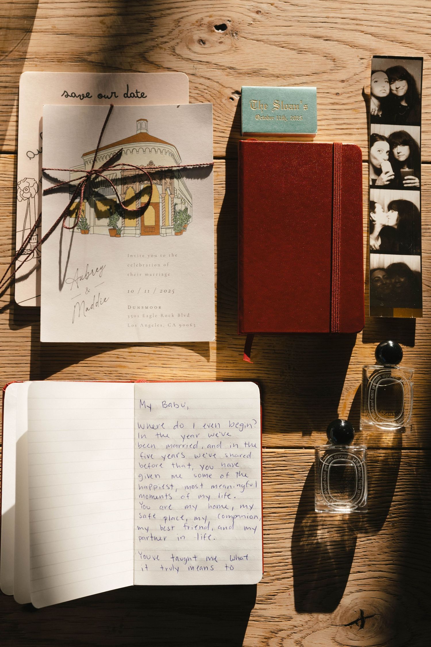 A flat lay of vintage journals, photo strips, and string lights on a wooden surface creating a nostalgic composition.
