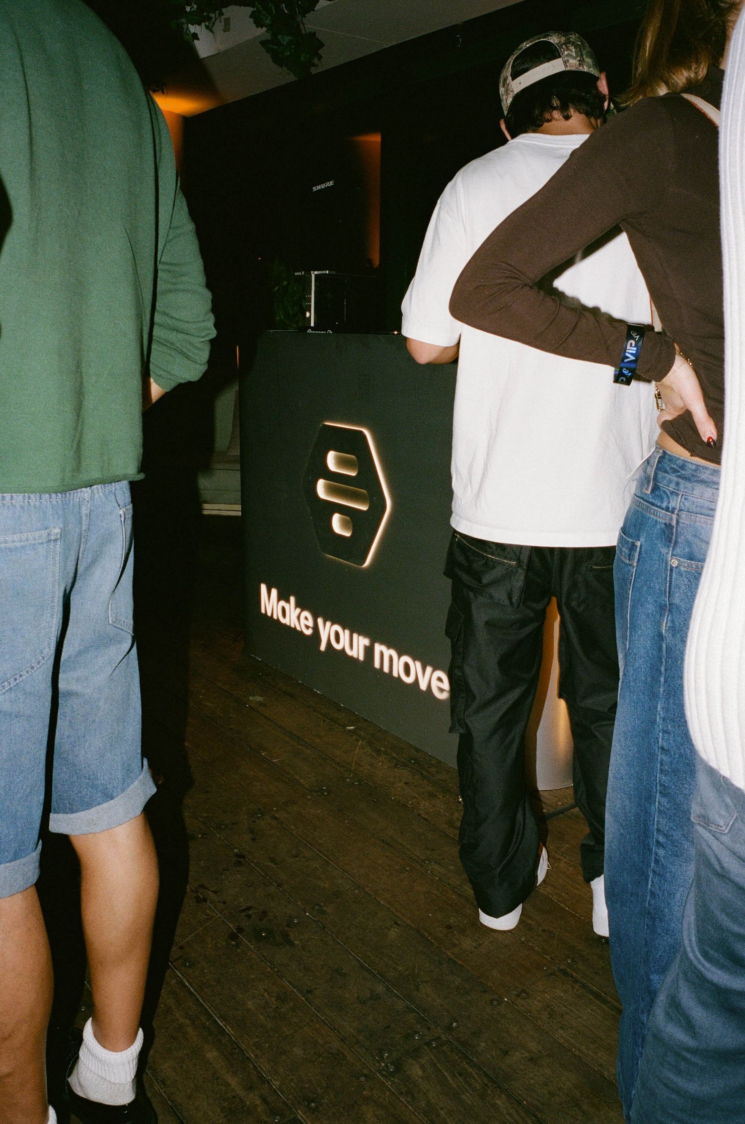 People gathered around a black branded display sign reading Make Your Move at an indoor event.