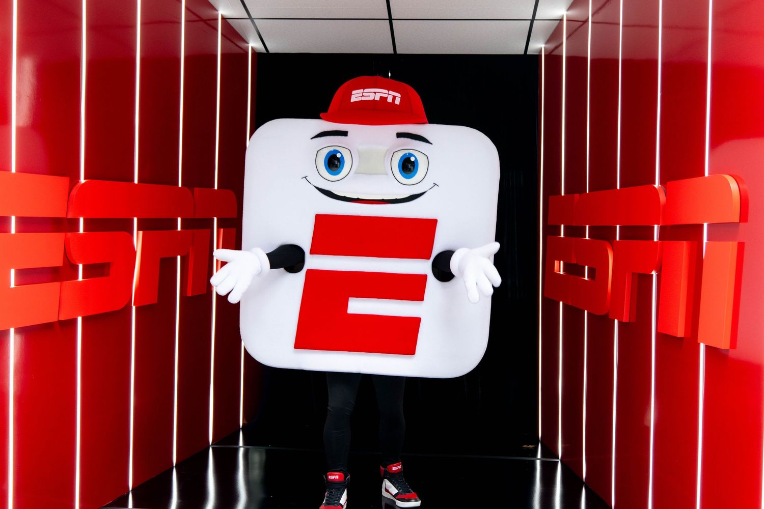 Red and white ESPN branded display wall with soccer ball pattern and decorative elements.