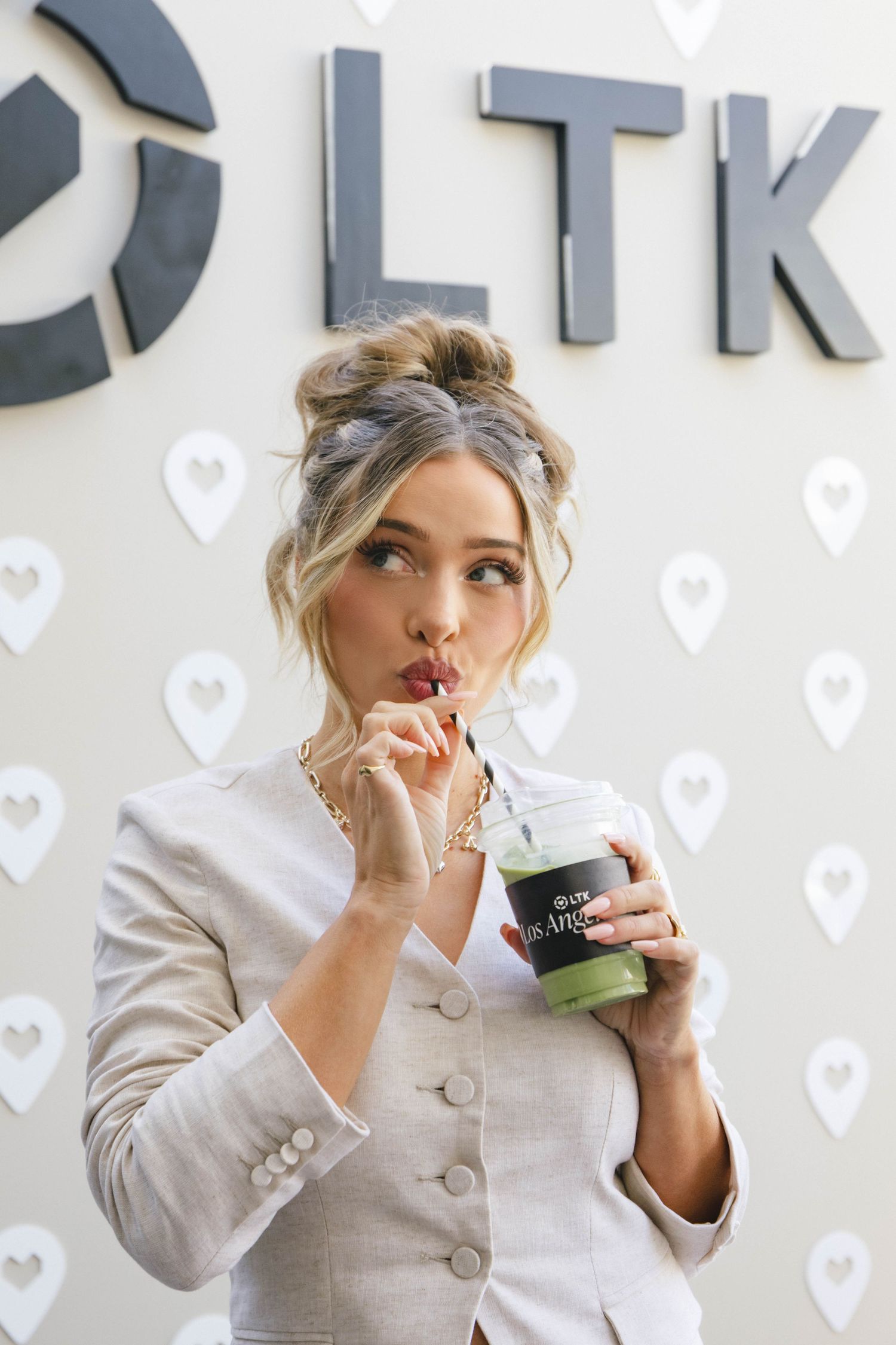 A series of three photos showing someone in a light colored blazer making playful expressions while drinking from a cup.
