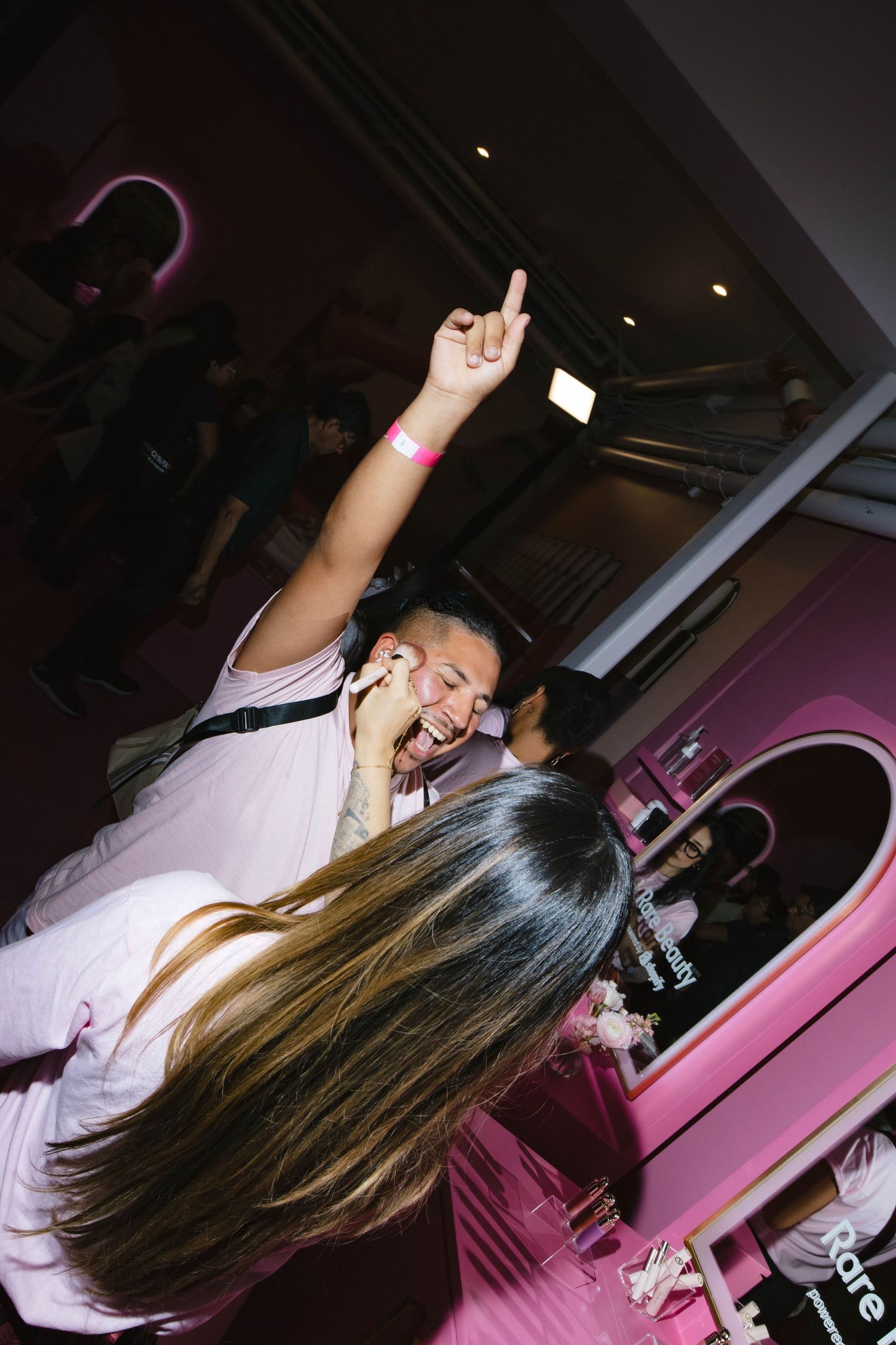 People celebrating at a pink-themed beauty product launch event.