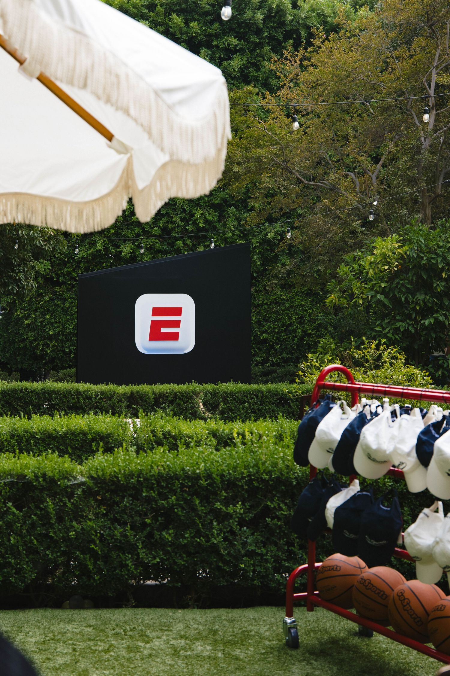 White decorative elements and displays set up on green lawn for outdoor event.