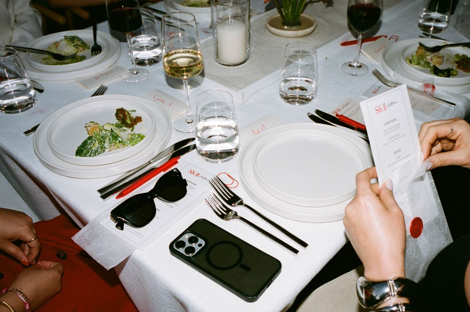 Place setting at an elegant dinner with menu card and smartphone on table.