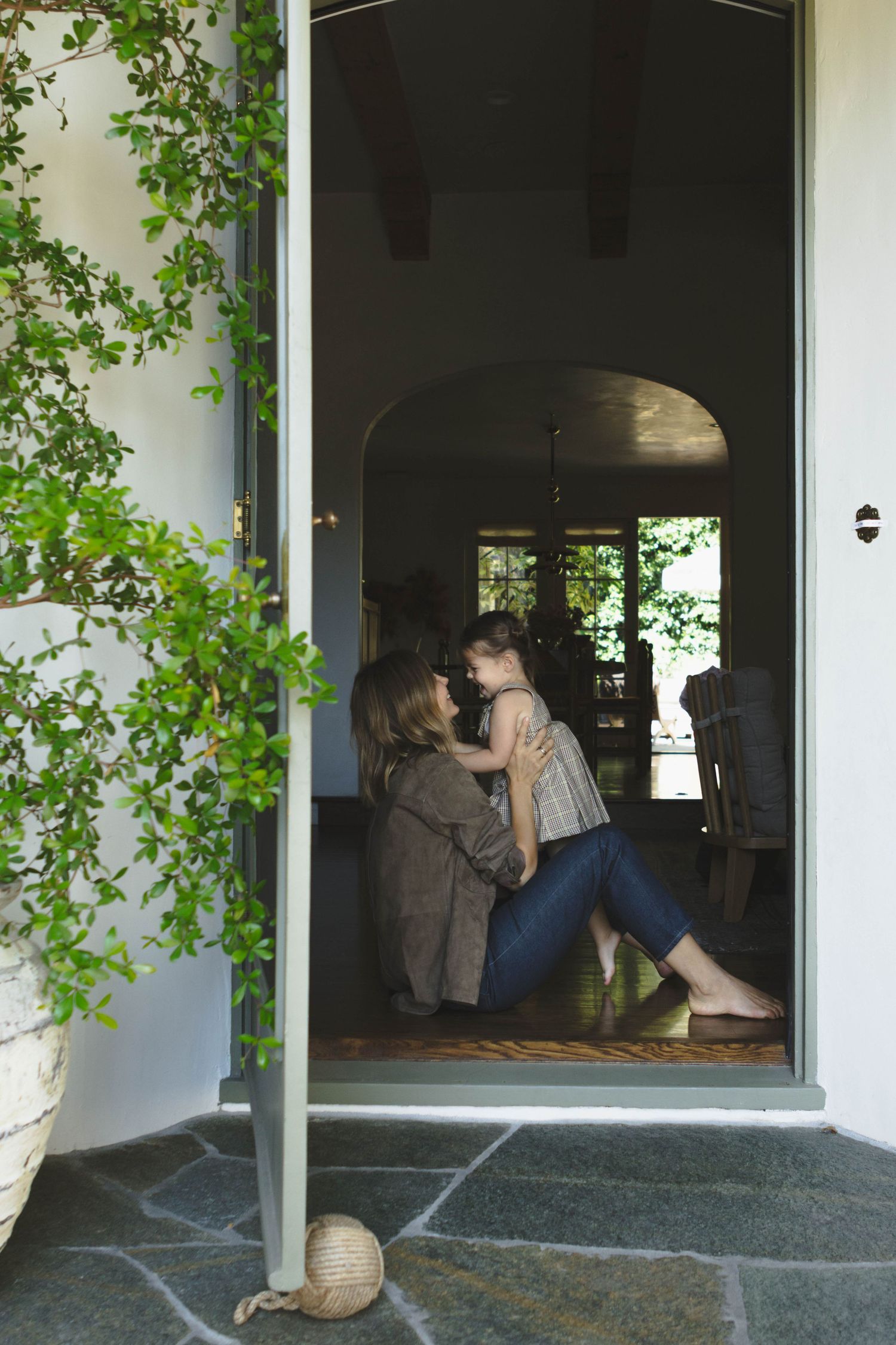 Series of intimate moments captured through doorway with green vines framing the entrance.
